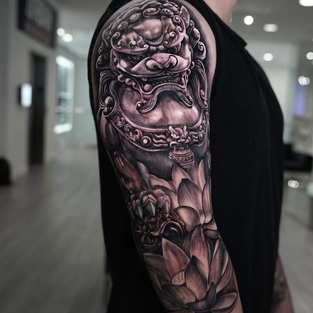 Foo dog and lotus flowers Japanese tattoo on the upper arm by Claude Steven Estrada, Las Vegas, Nevada