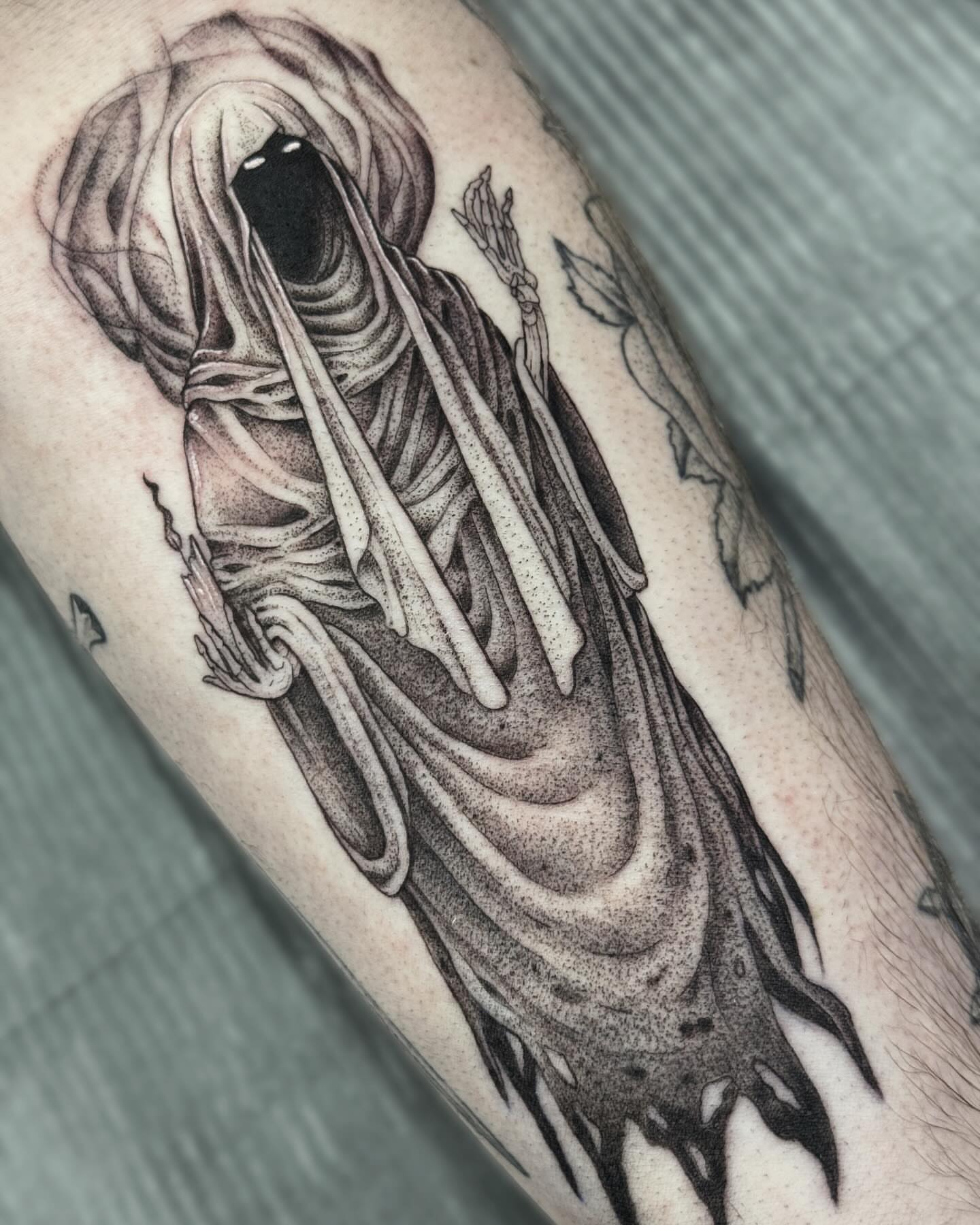 Ghostly figure dotwork tattoo on the forearm by Writhe Grey