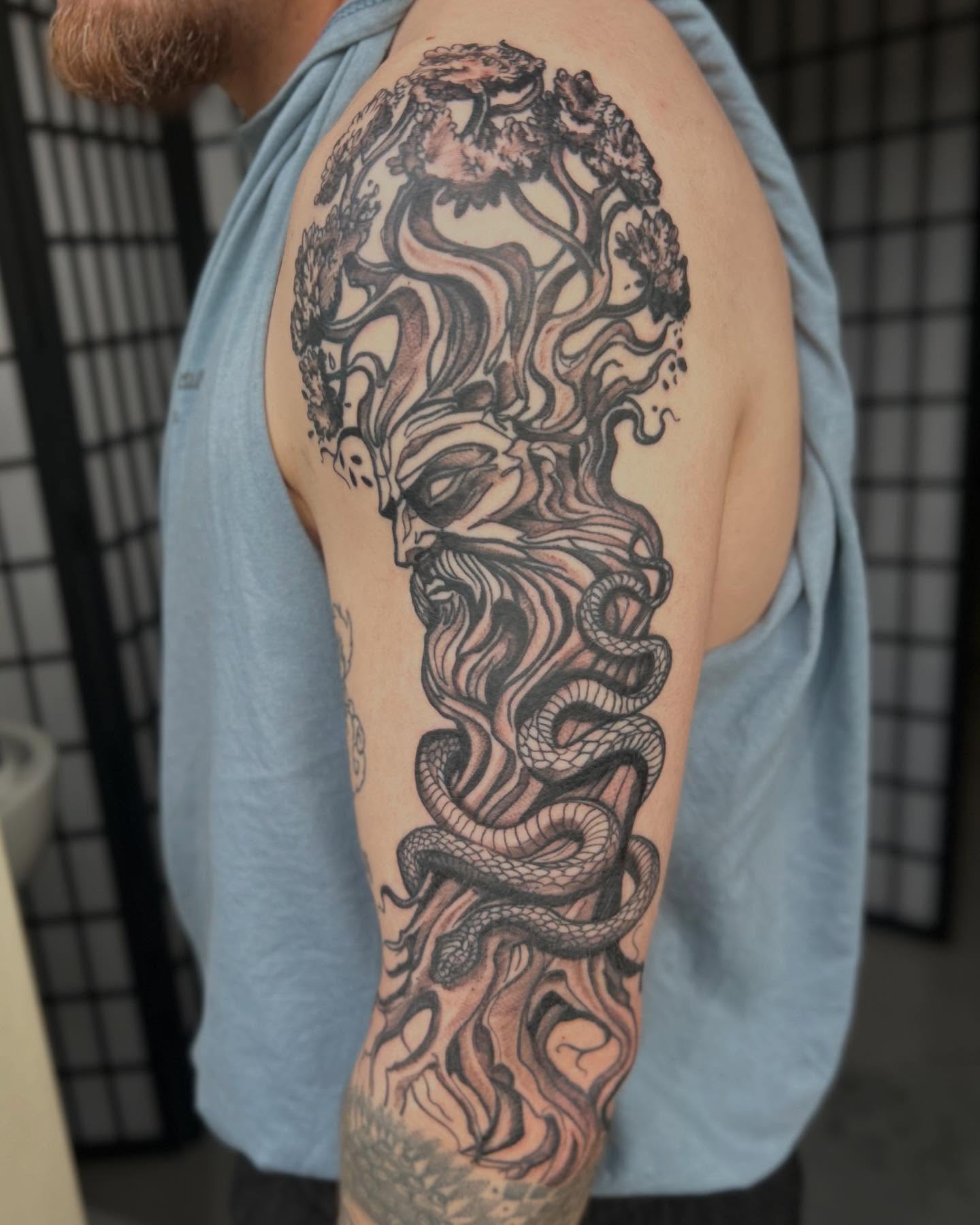 Snake and tree realism tattoo on the upper arm by ɢɢ sᴛʏʟᴇs