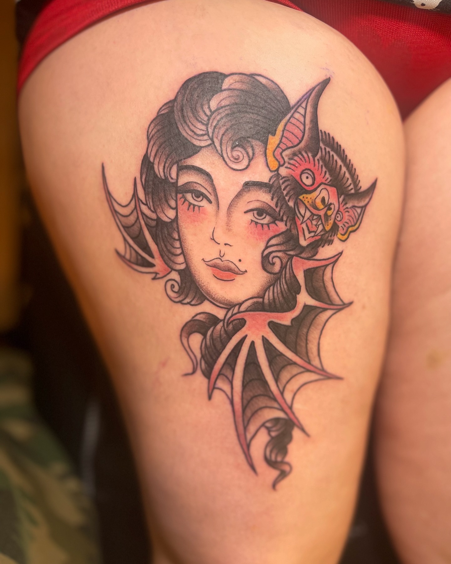 Woman with horns American traditional tattoo on the thigh by Alex