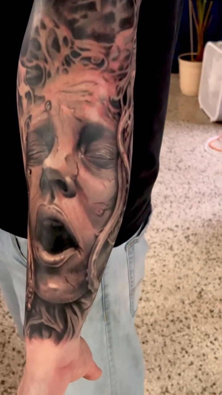 Screaming face and skulls dark realism tattoo by Krys King Tattoos