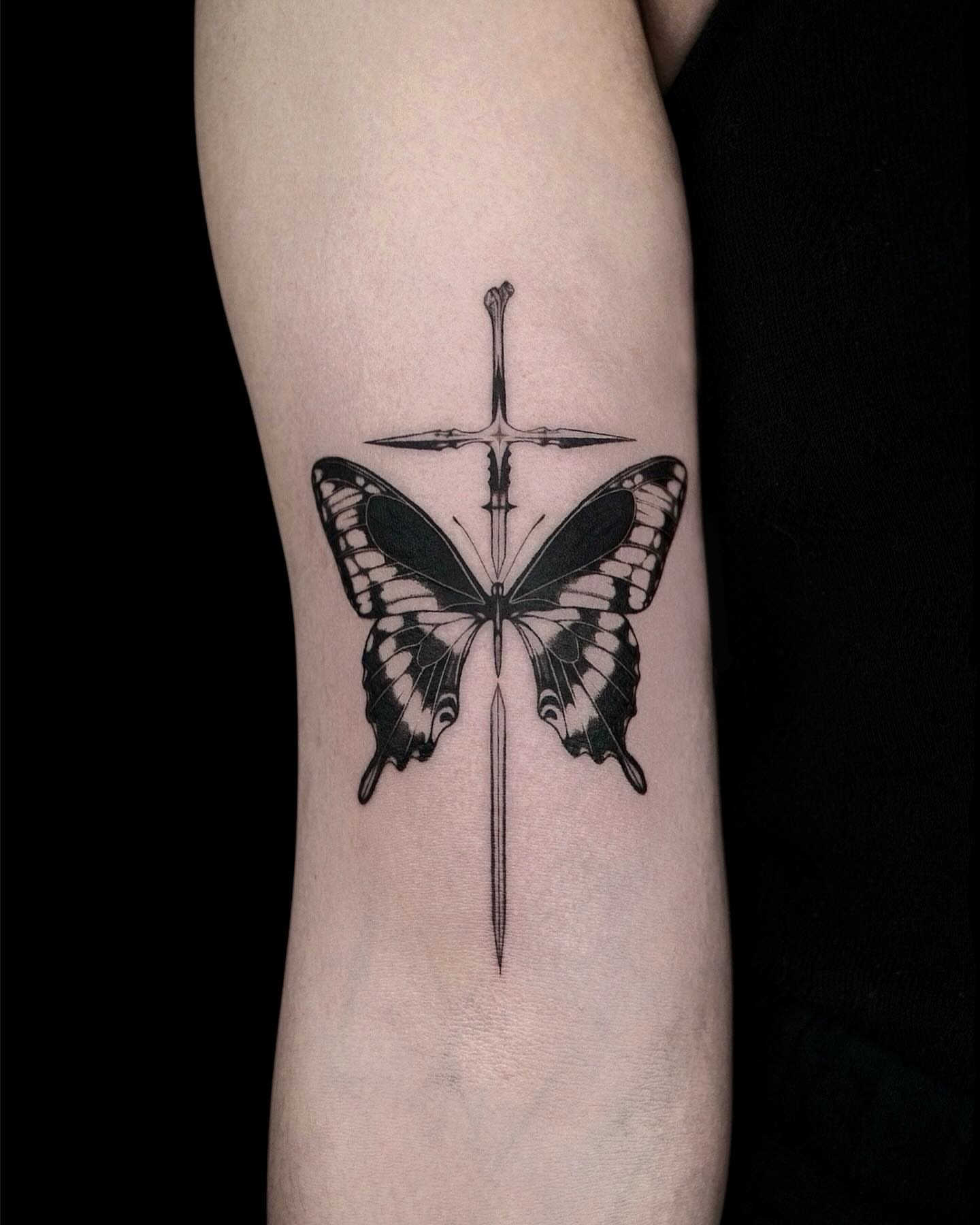 Butterfly and sword black and grey tattoo on the forearm by 𝑴𝒆𝒍𝒐