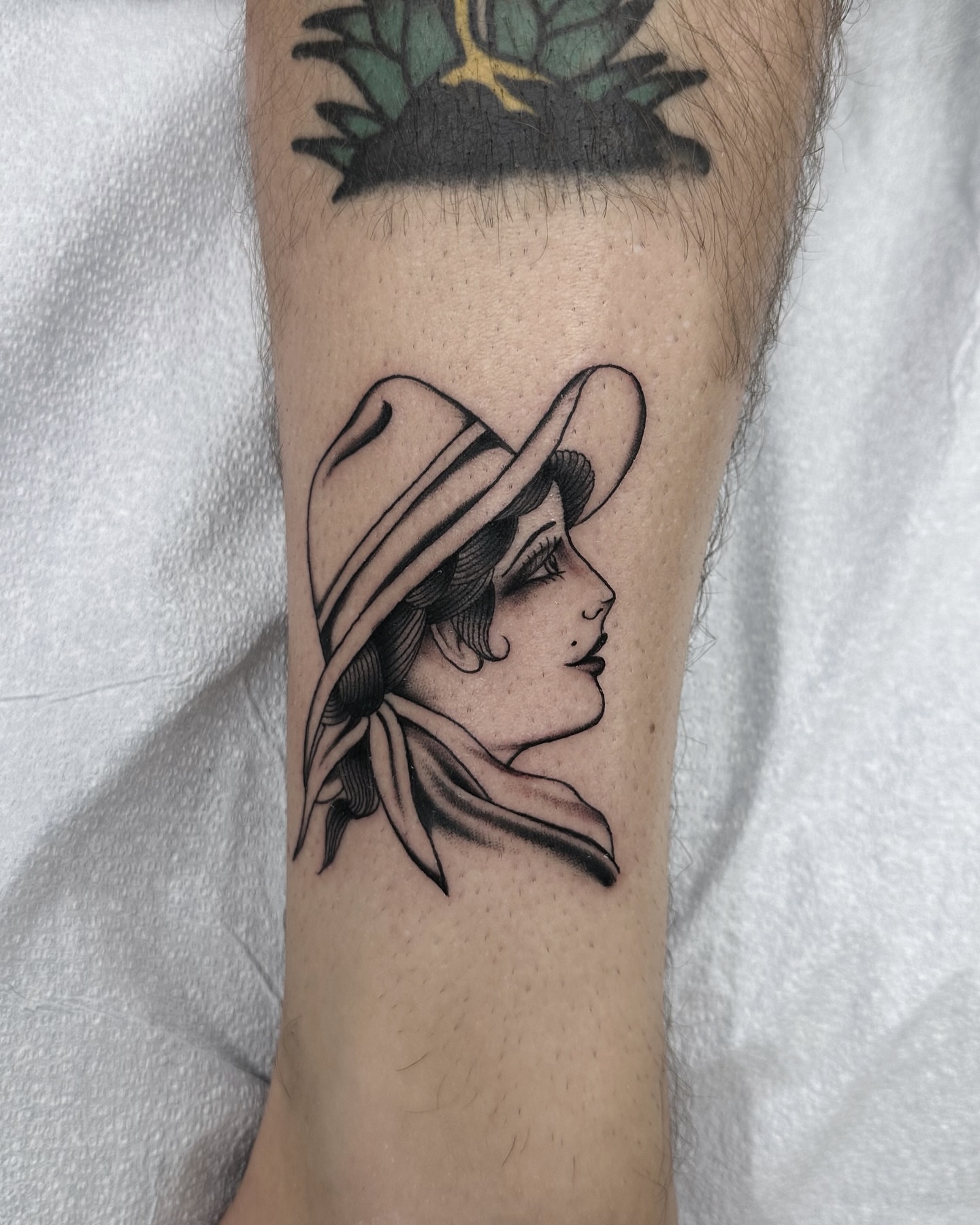 Woman wearing hat black and grey tattoo on the forearm by Nicholas Lee, San Francisco, California
