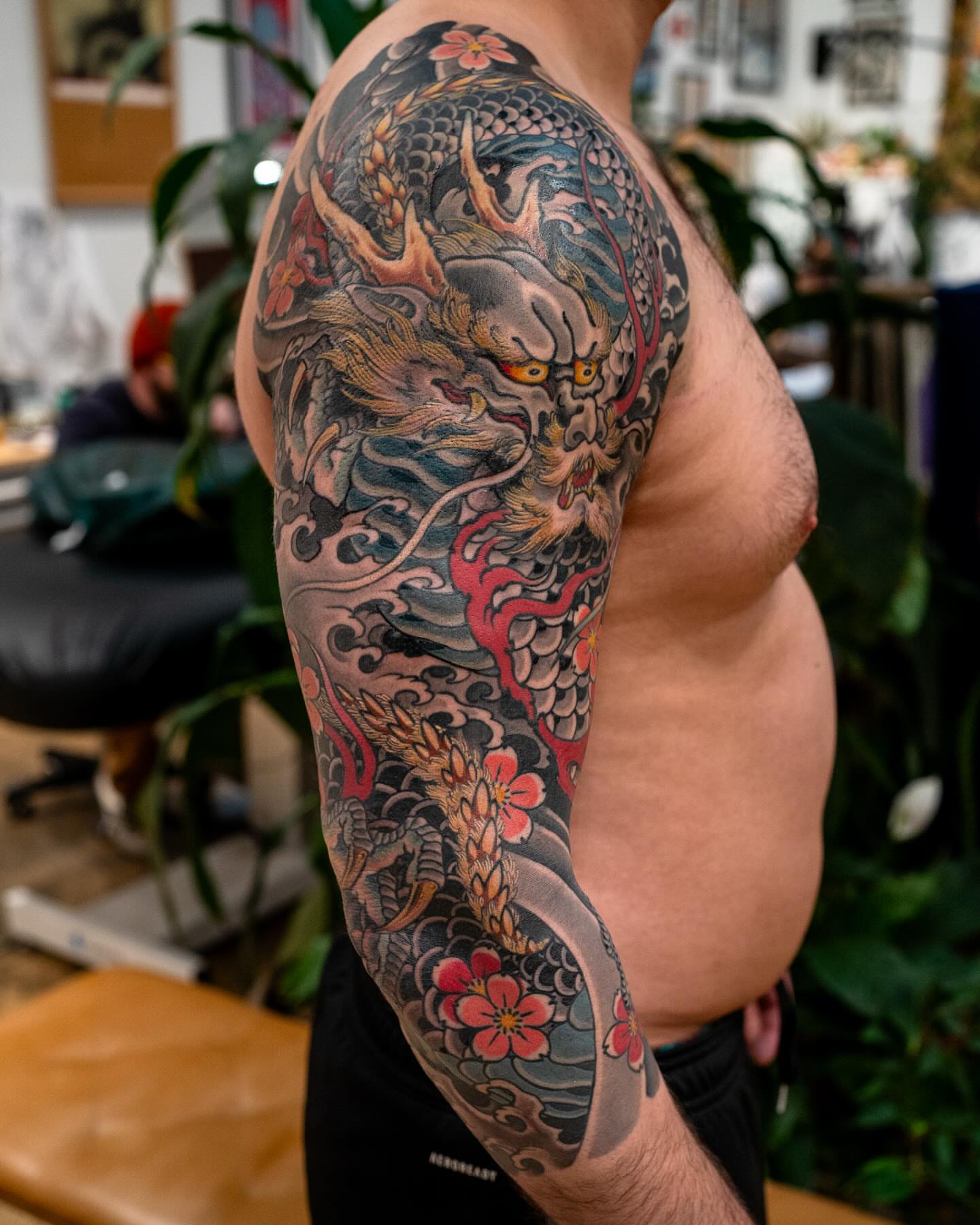 Dragon and flowers japanese irezumi tattoo on the upper arm by Matt Leibo, San Francisco, California