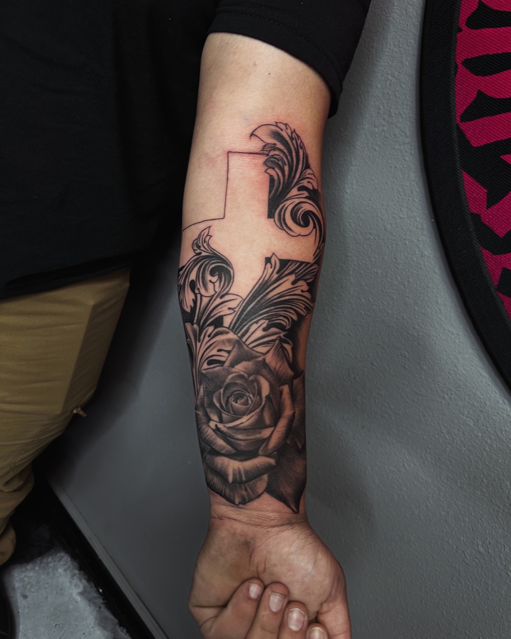Rose and scrollwork realism tattoo on the forearm by 📍 Austin