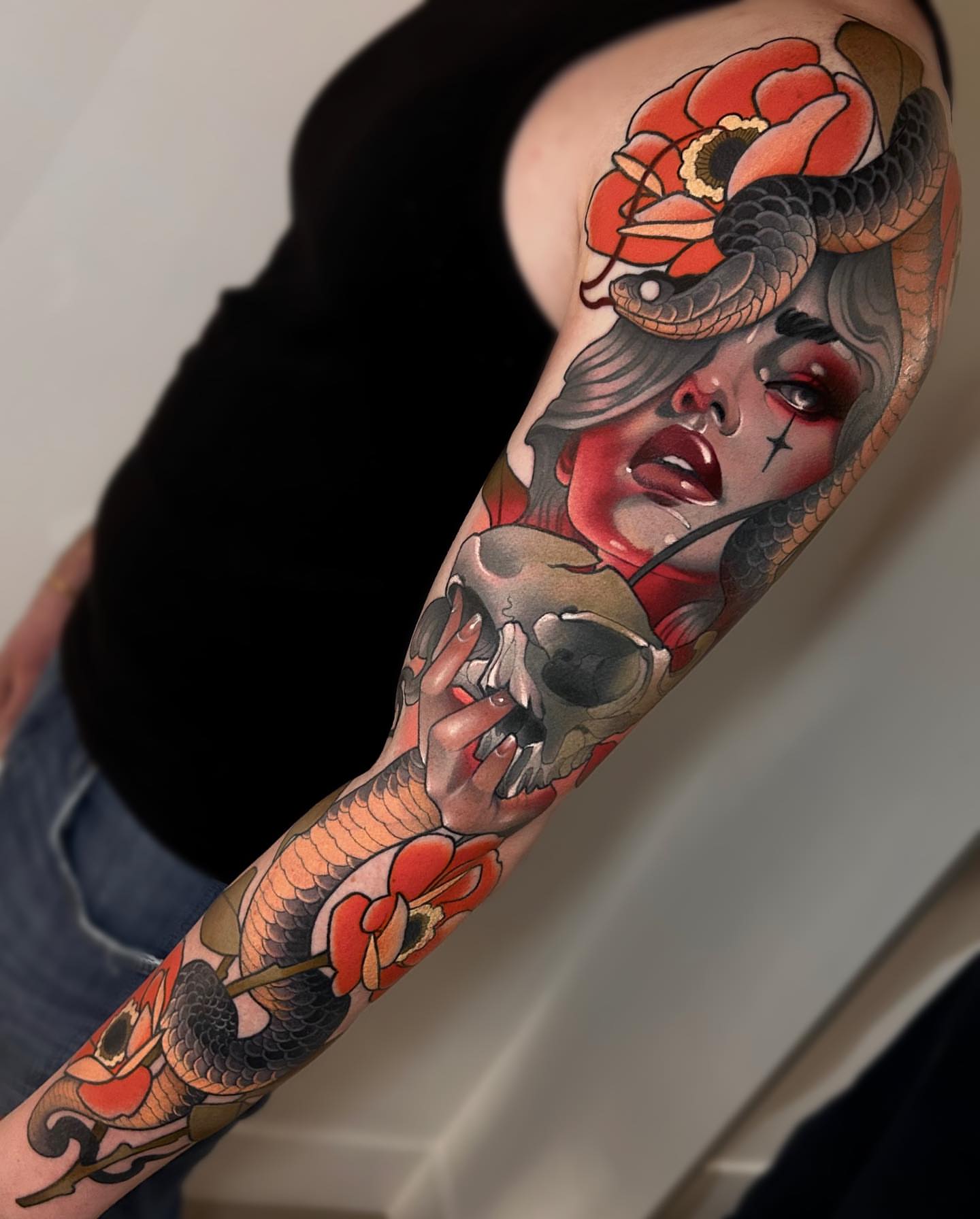 Woman with snake and skull American traditional tattoo on the forearm by Levi Murphy