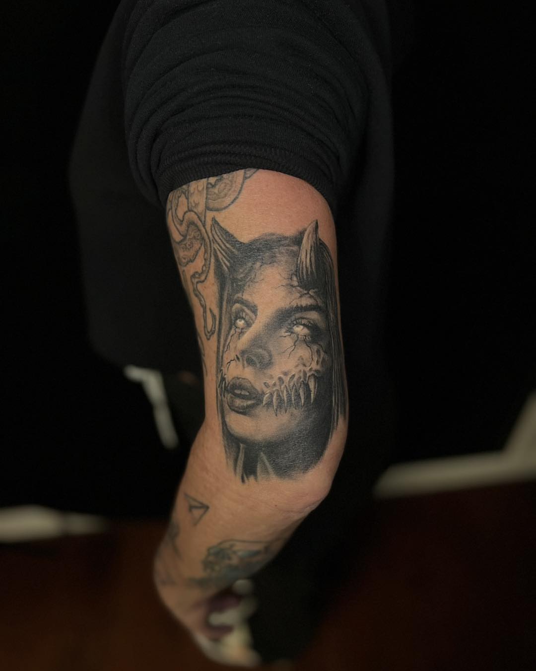 Woman with demonic features realism tattoo on the forearm by James Reed Tattoo artist