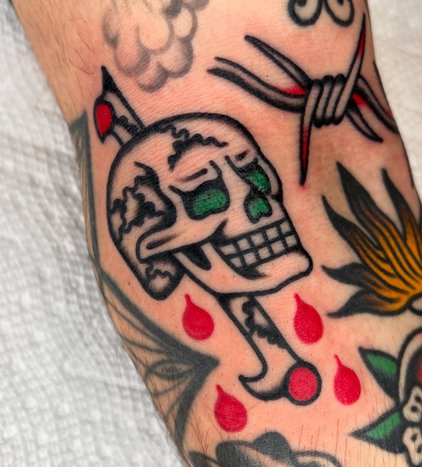 Skull with cherries American traditional tattoo on the forearm by Ian Jett