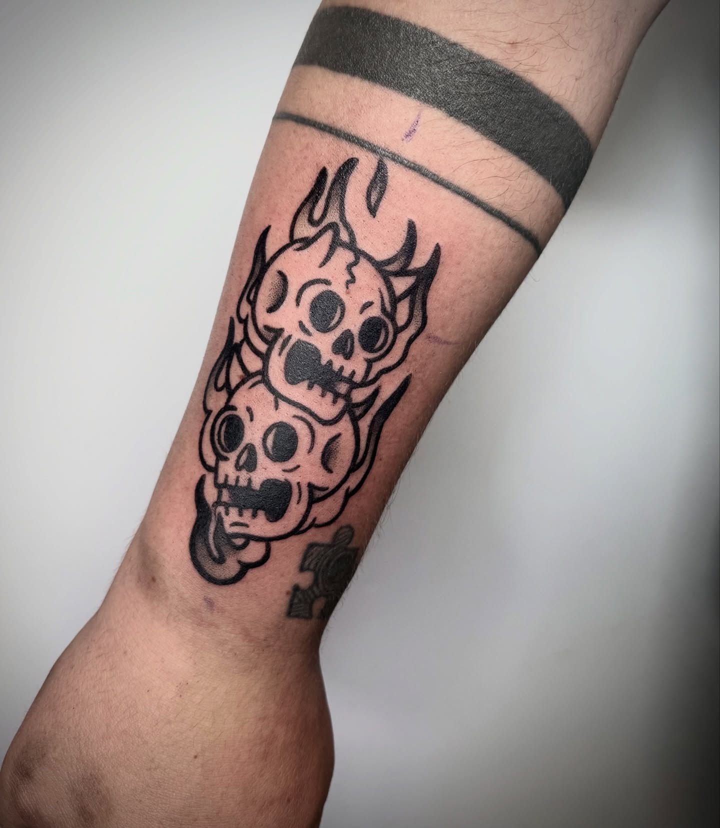 Skulls black and grey tattoo on the forearm by Abrianna