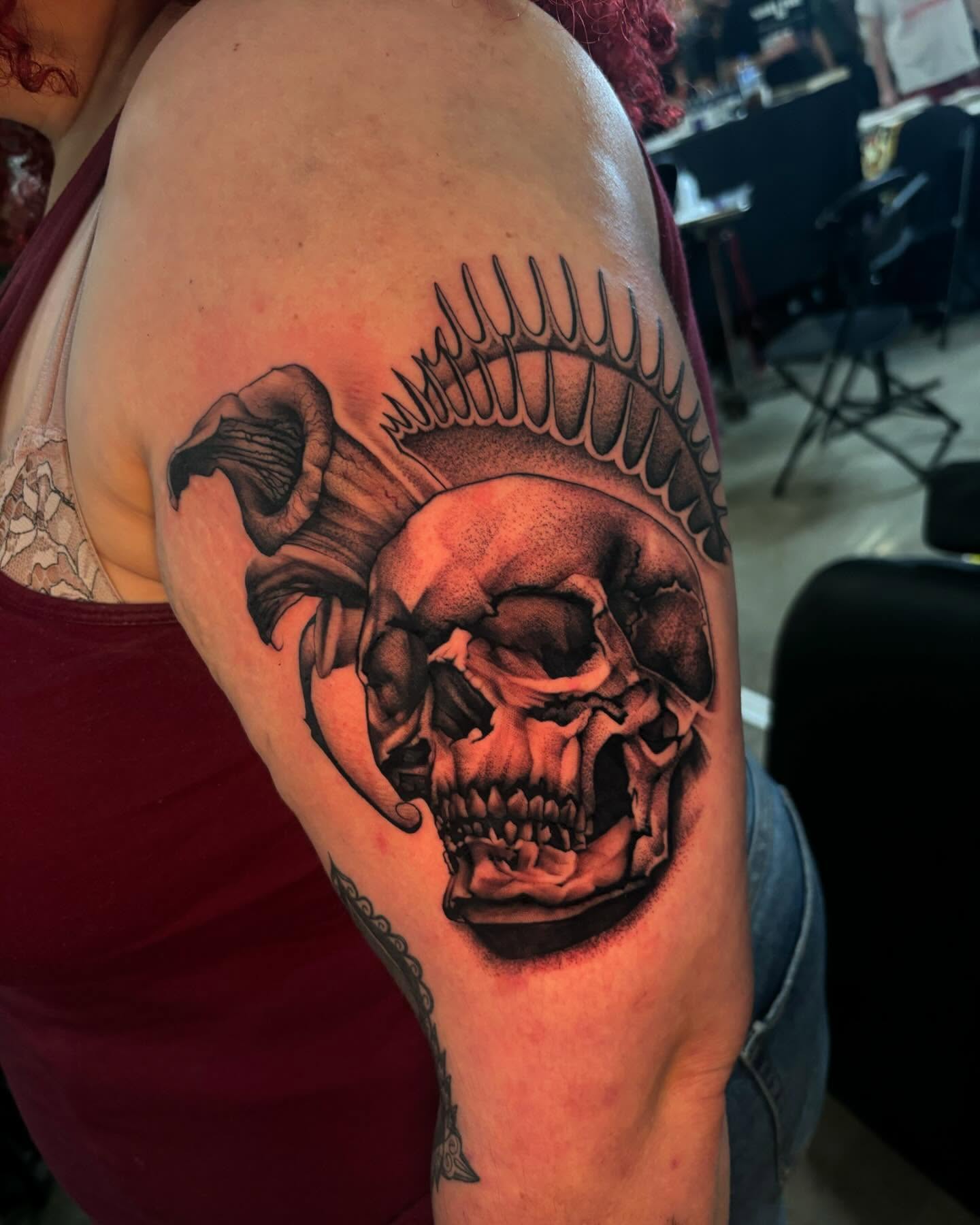 Skull with feathers realism tattoo on the shoulder by orlando
