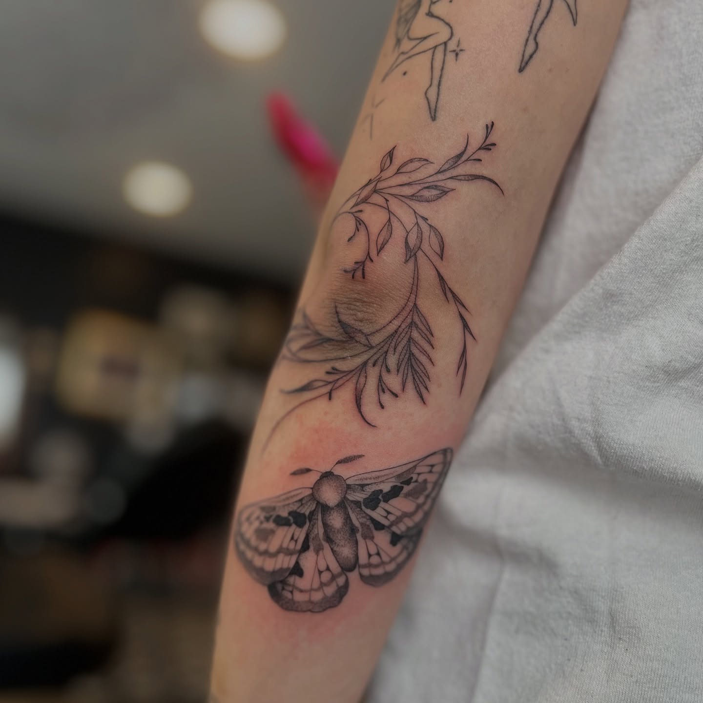 Moth and leaf black and grey tattoo on the forearm by Dom