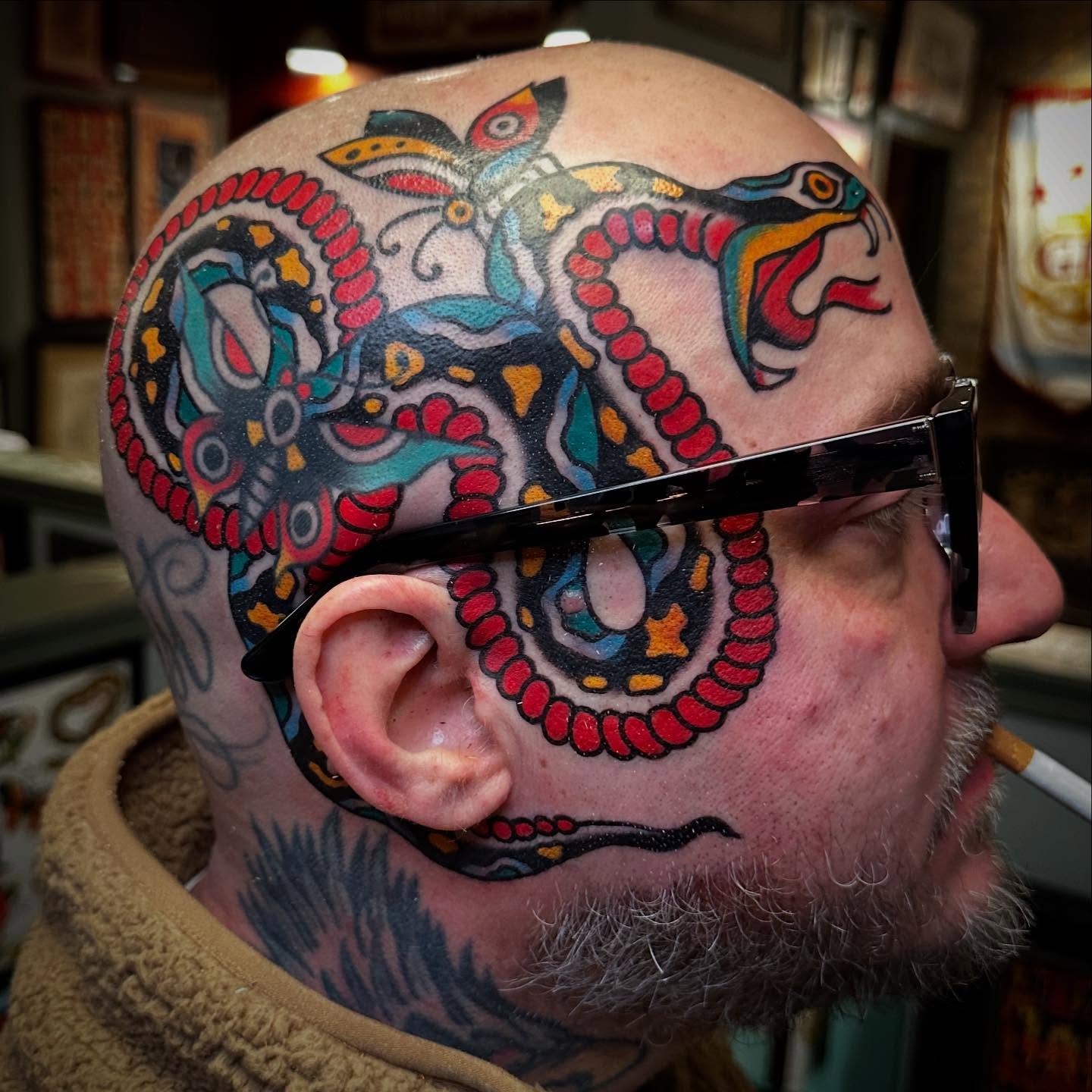 Snake and peony American traditional tattoo on the head by Nathan Rohrbacher, Nashville, Tennessee