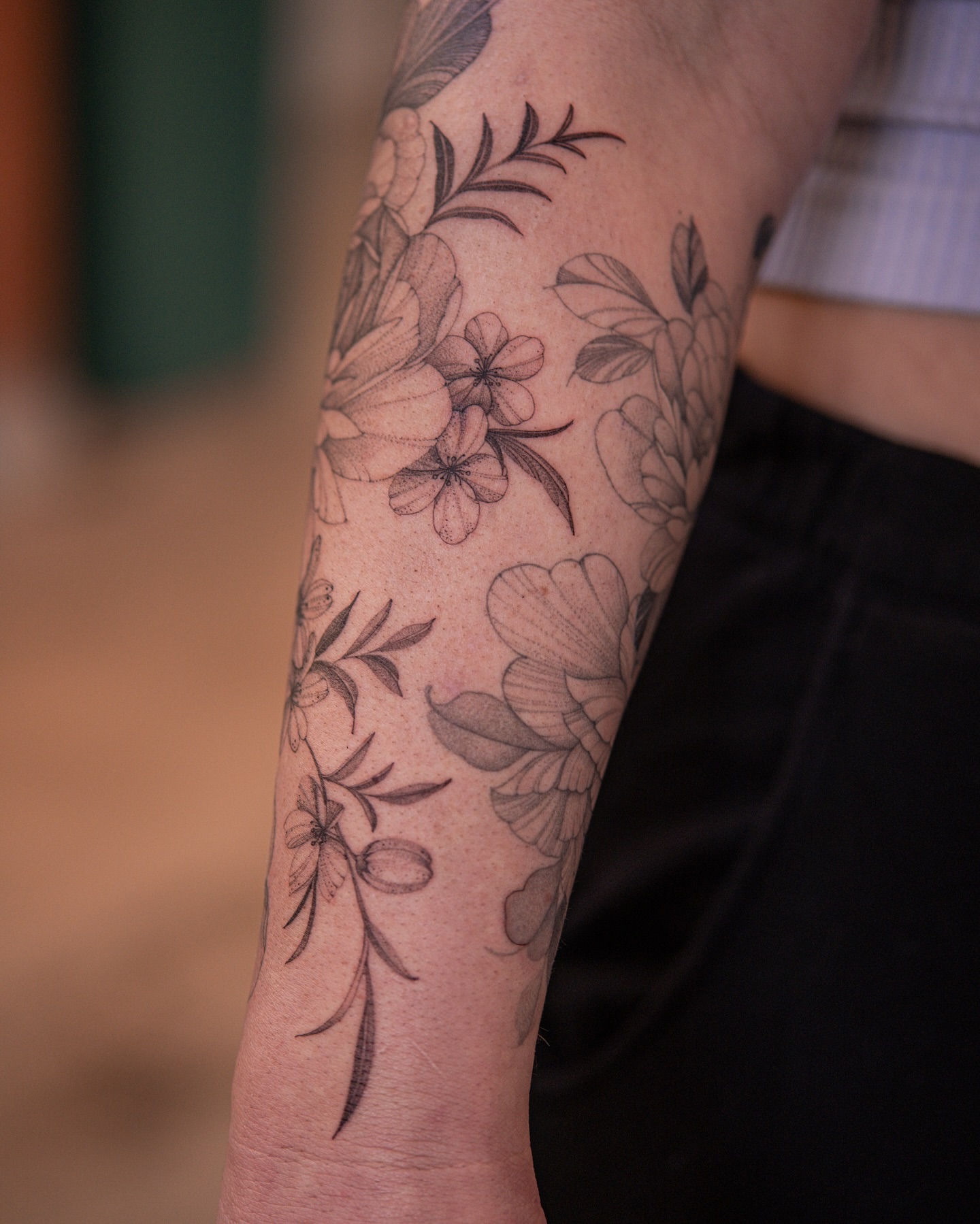 Floral arrangement black and grey tattoo on the forearm by Flower Tattoo Sf