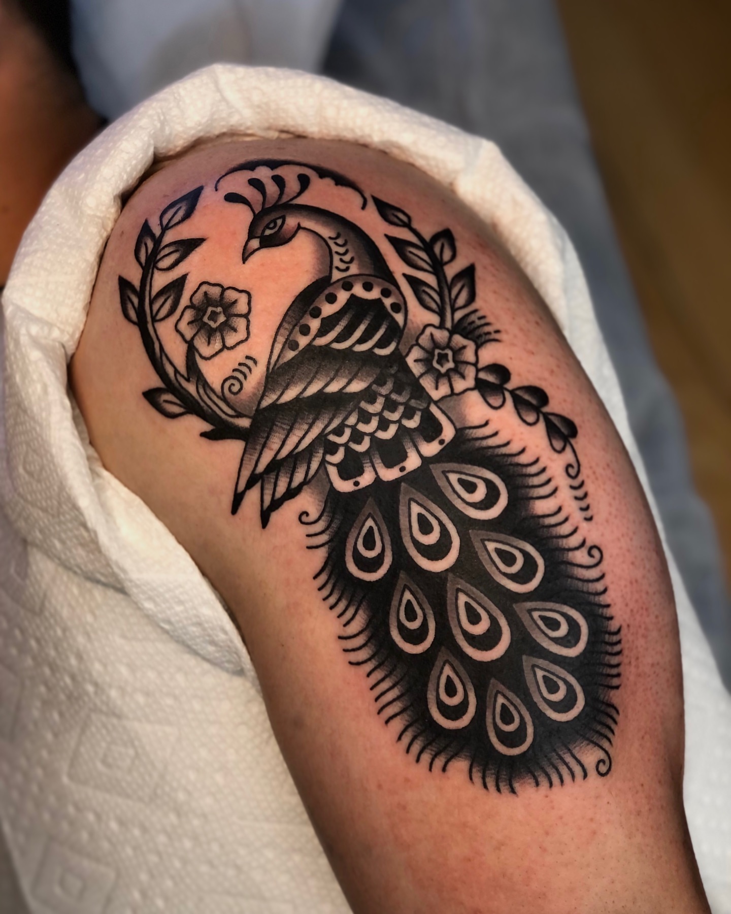 Peacock black and grey tattoo on the shoulder by EVA Traditional Tattoos