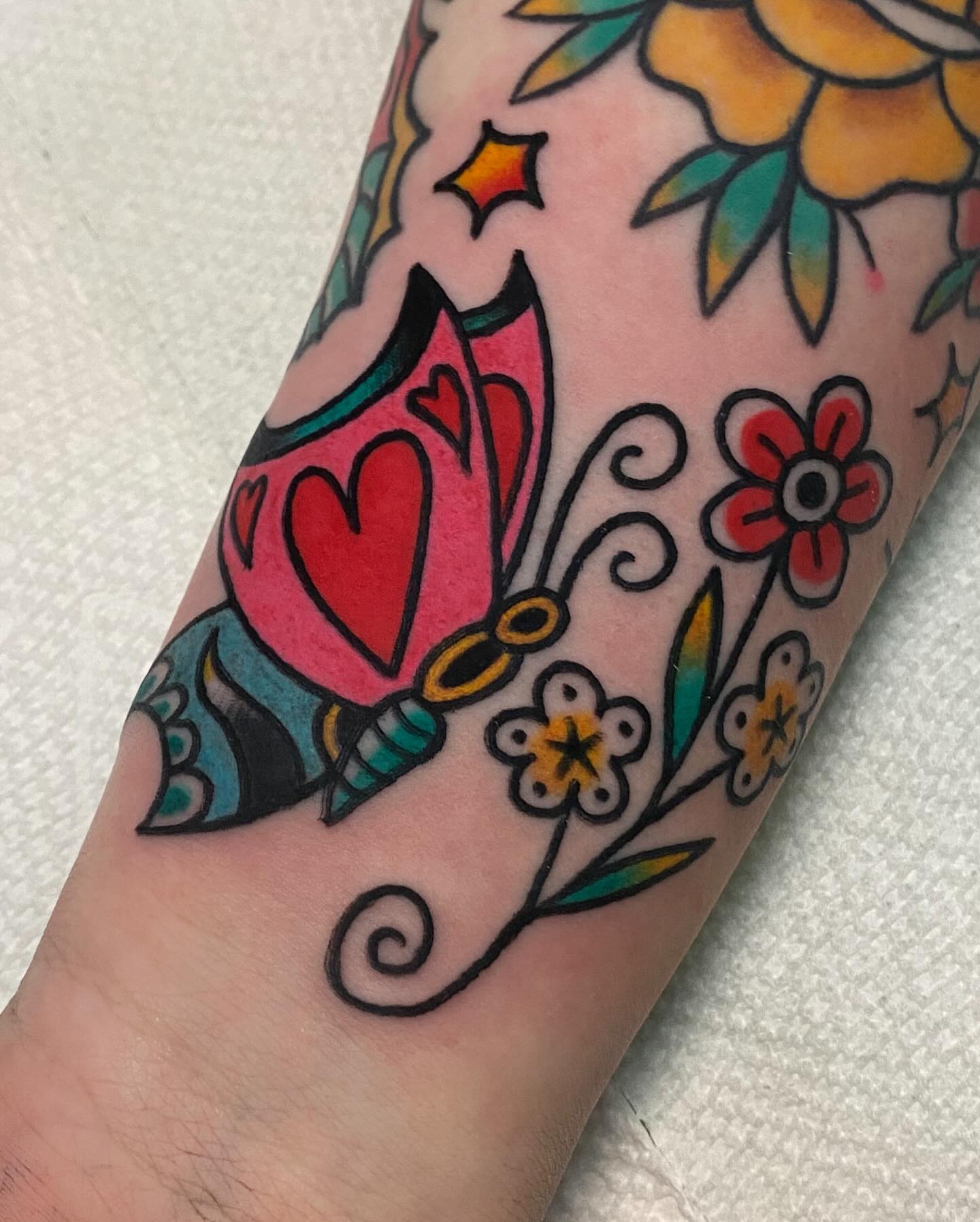 Heart and floral American traditional tattoo on the forearm by Shana