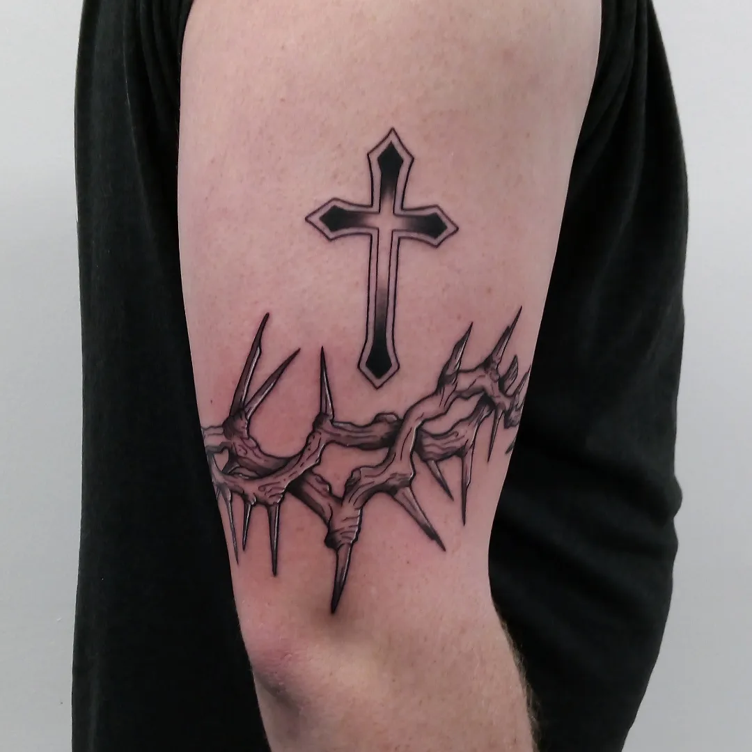 Cross and crown of thorns black and grey tattoo on the forearm by Cassandra Davis