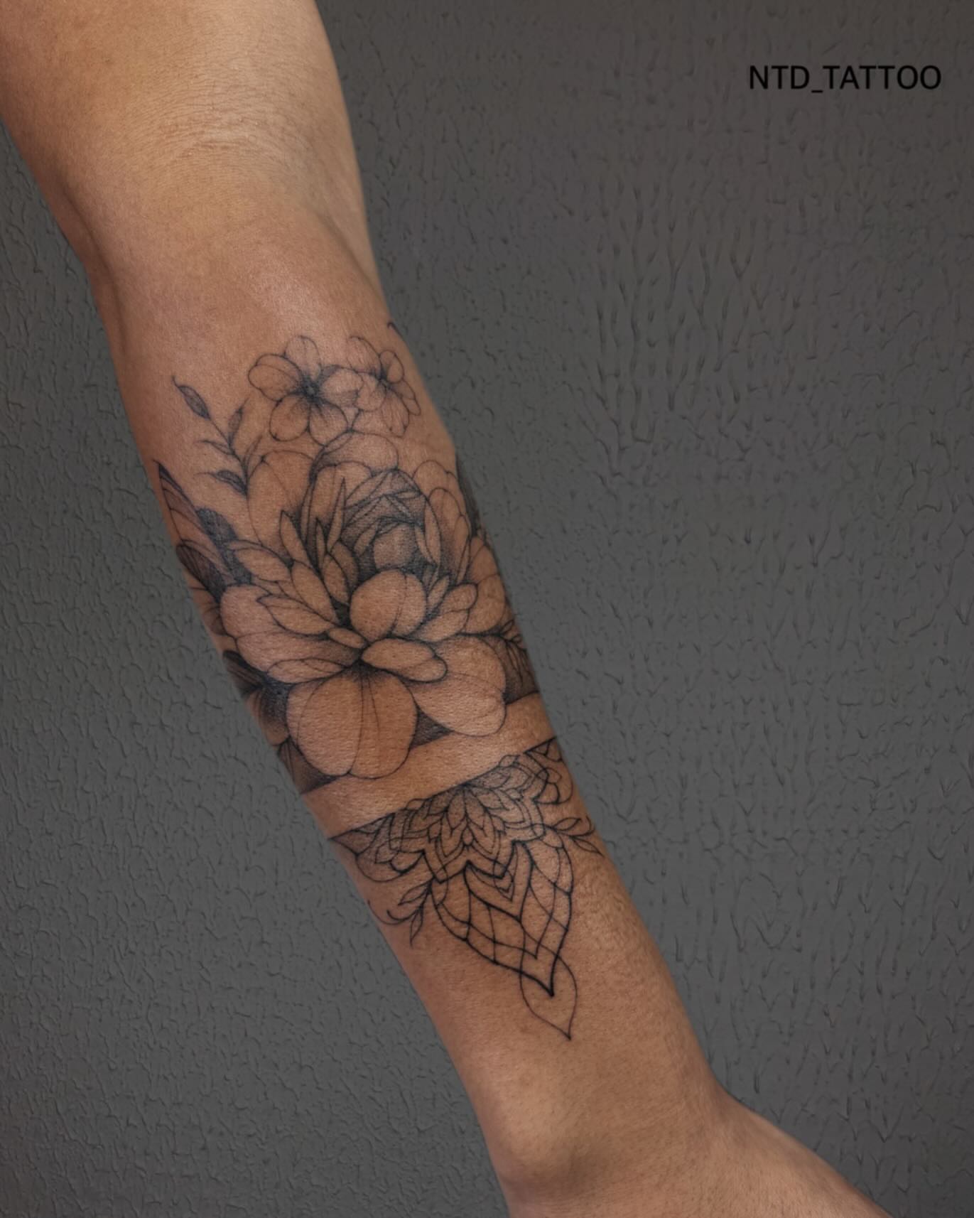Floral bouquet black and grey tattoo on the forearm by Tetiana Maxon