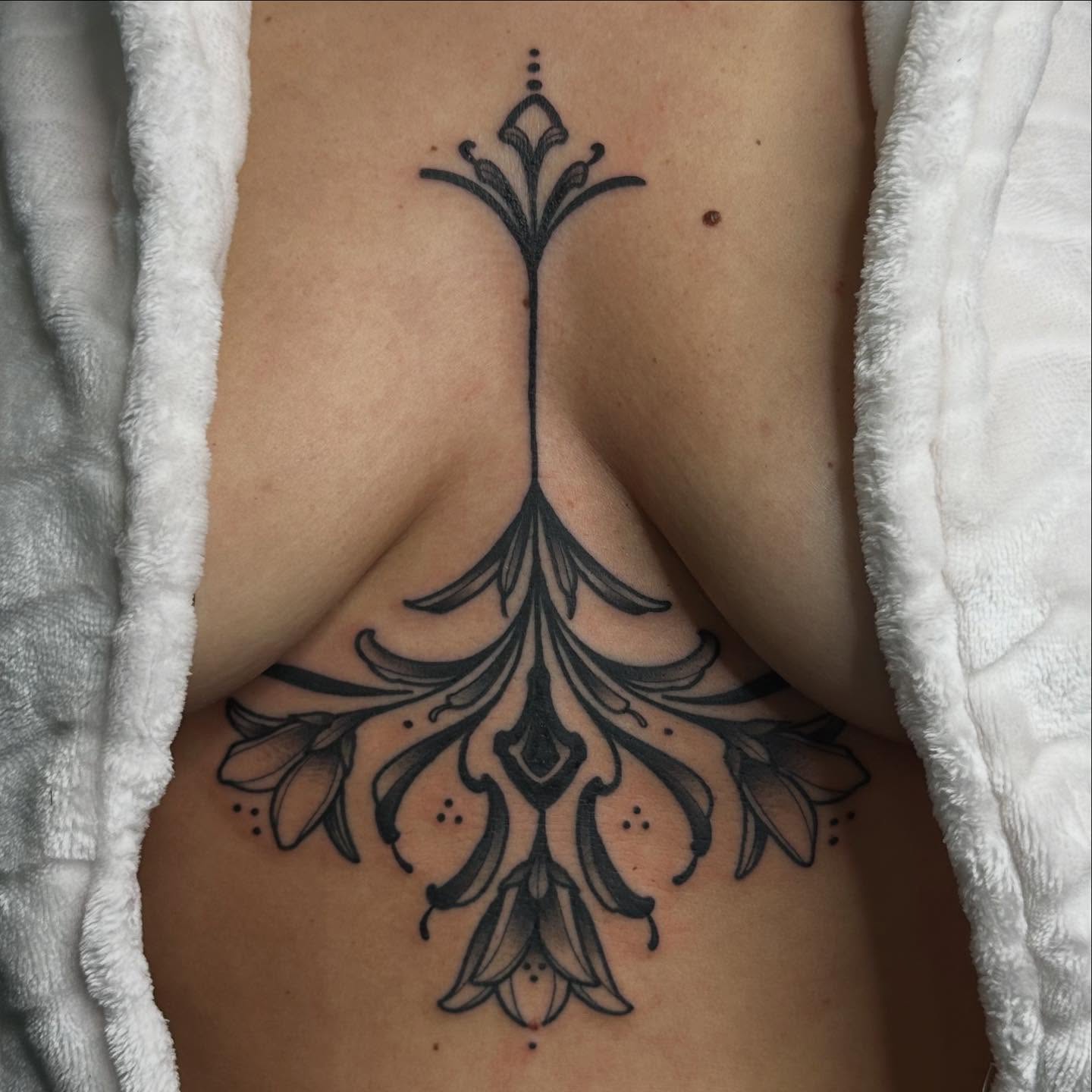 Floral design ornamental tattoo on the ribs by Shelby Raia
