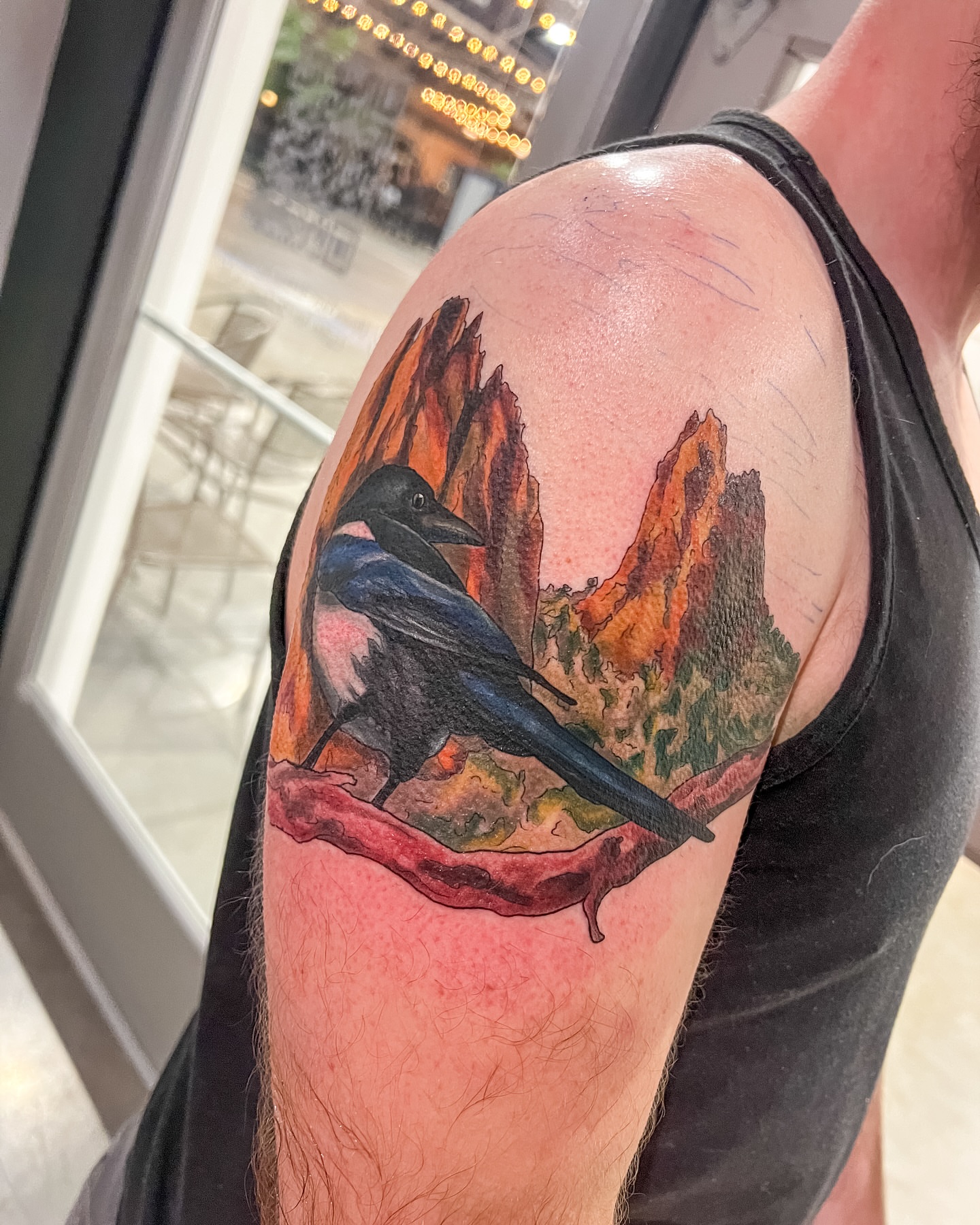 Bird and landscape realism tattoo on the shoulder by Reagan Sutton