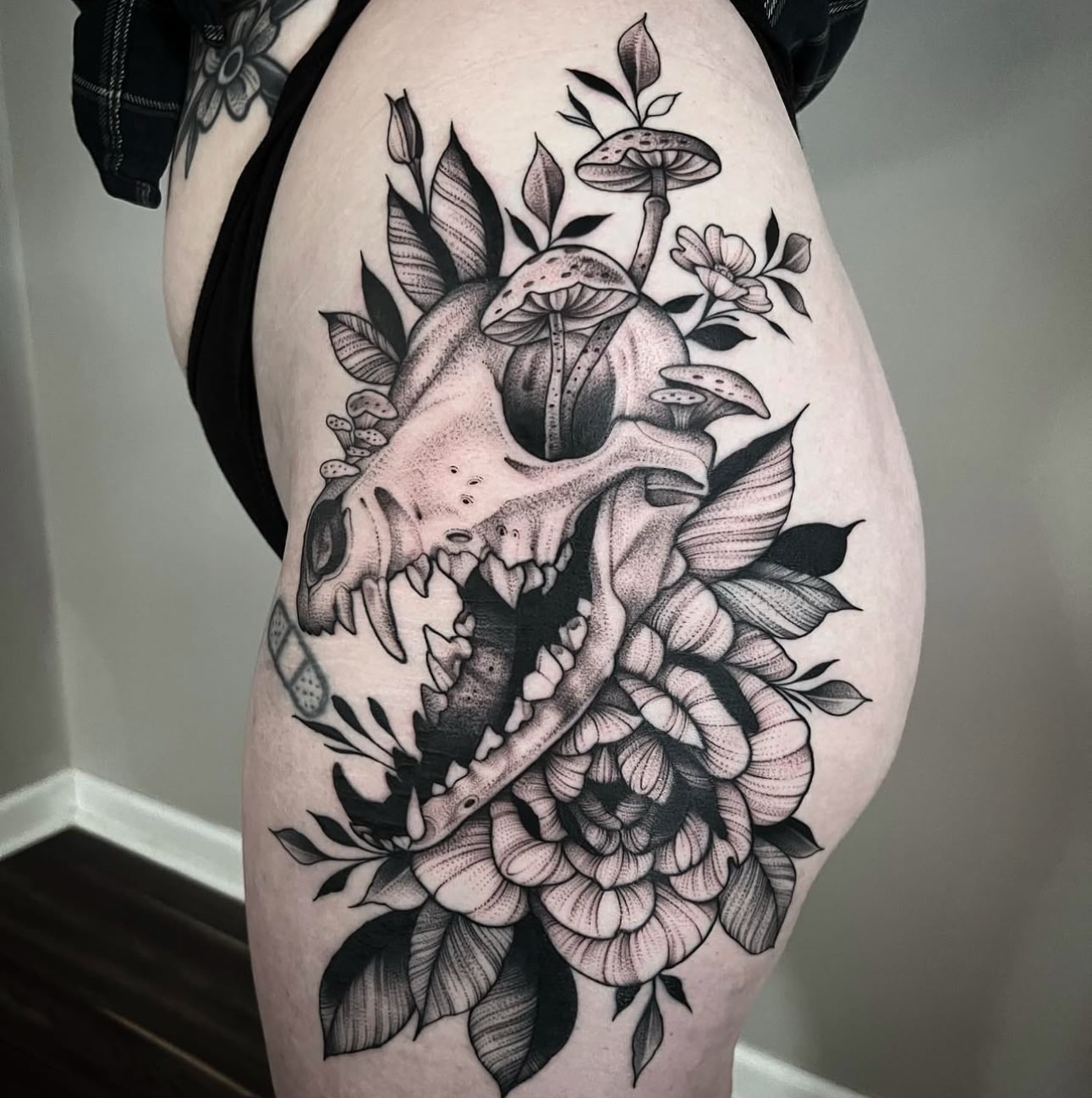 Skull and floral dotwork tattoo on the thigh by Sterling Grice