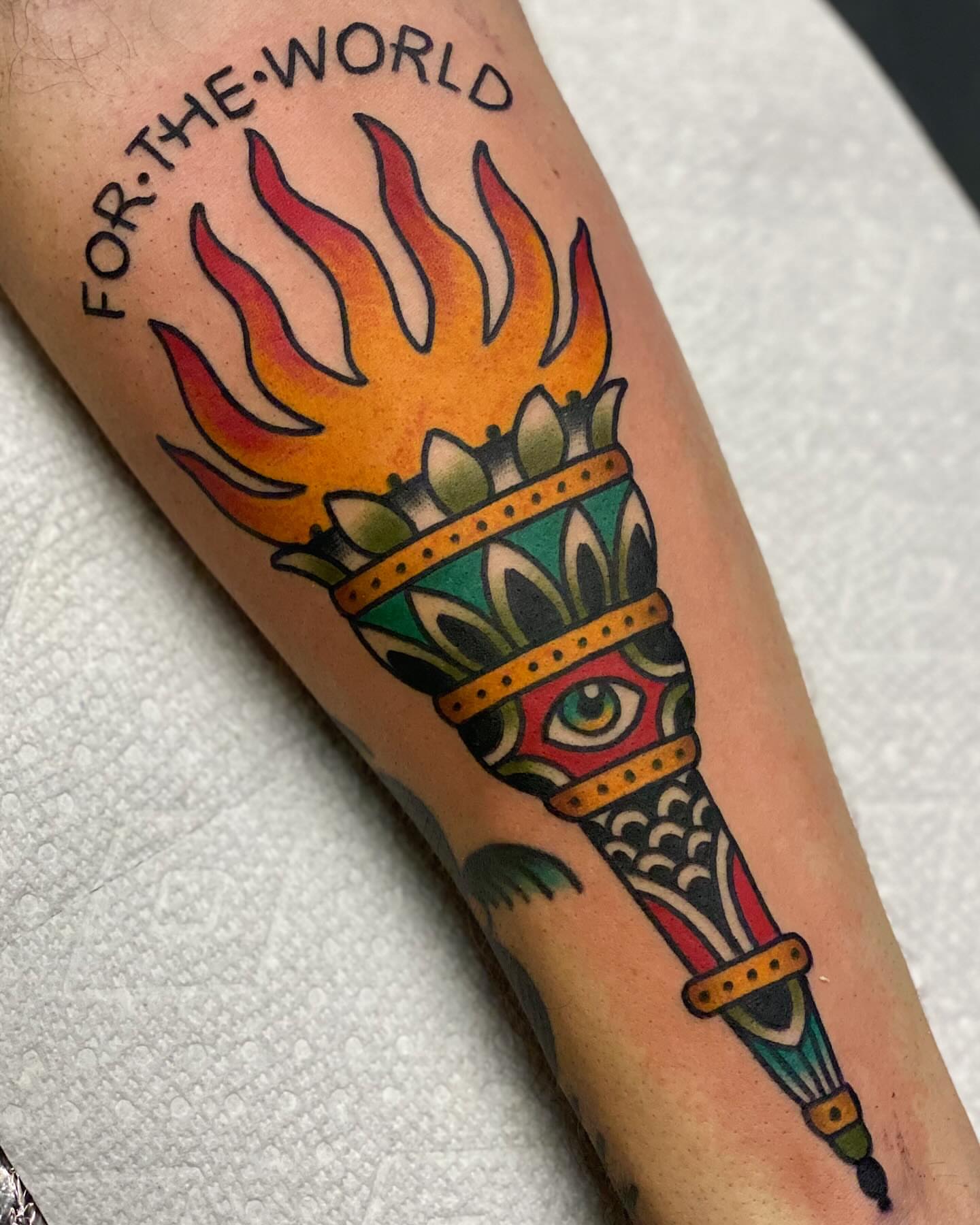 Flame and headdress American traditional tattoo on the forearm by Dakota Amato