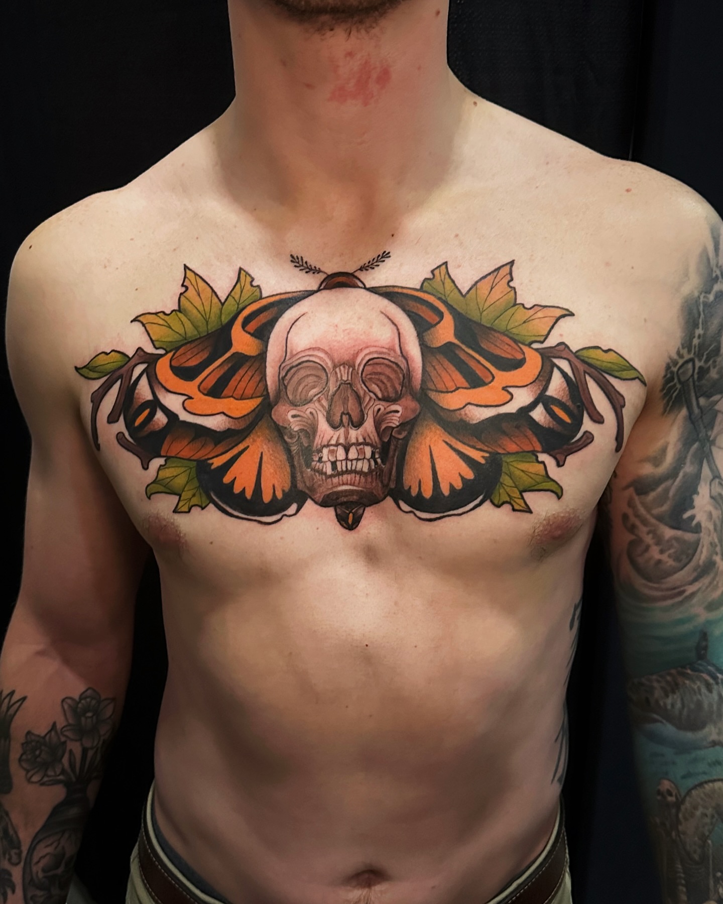Skull and butterfly American traditional tattoo on the chest by Kelsey Zussman