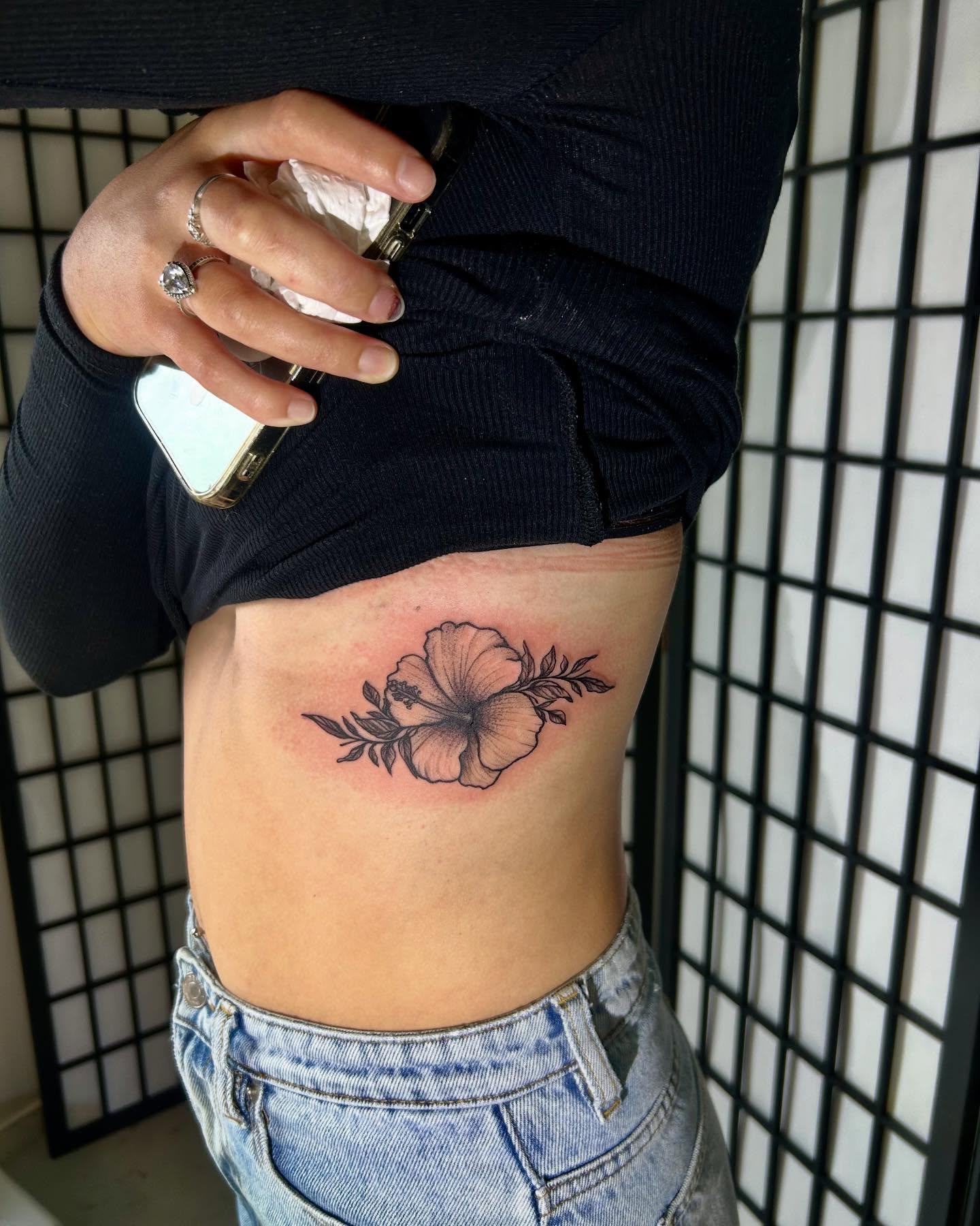 Hibiscus flower black and grey tattoo on the ribs by ɢɢ sᴛʏʟᴇs