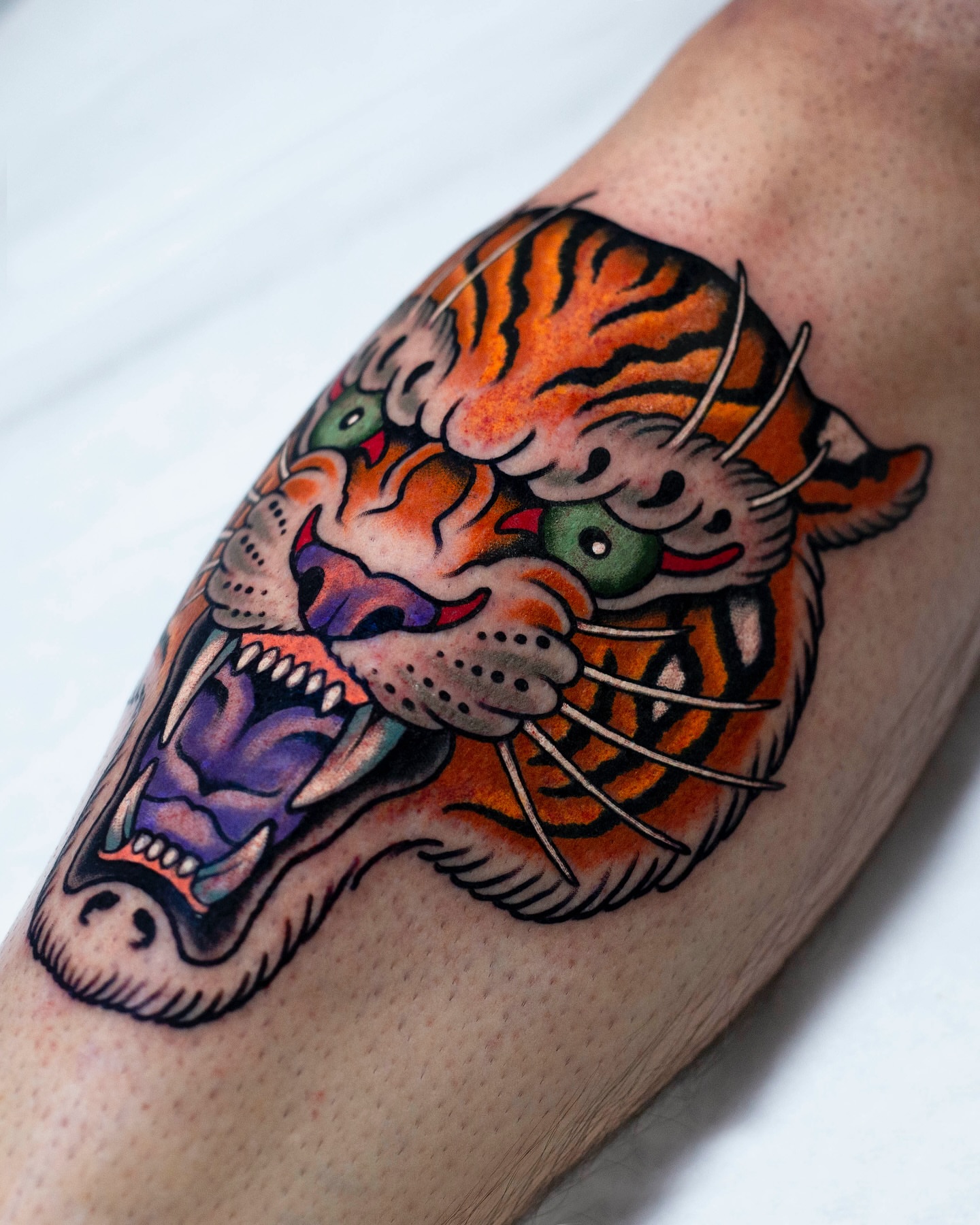 Tiger head American traditional tattoo on the forearm by Miguel Comin