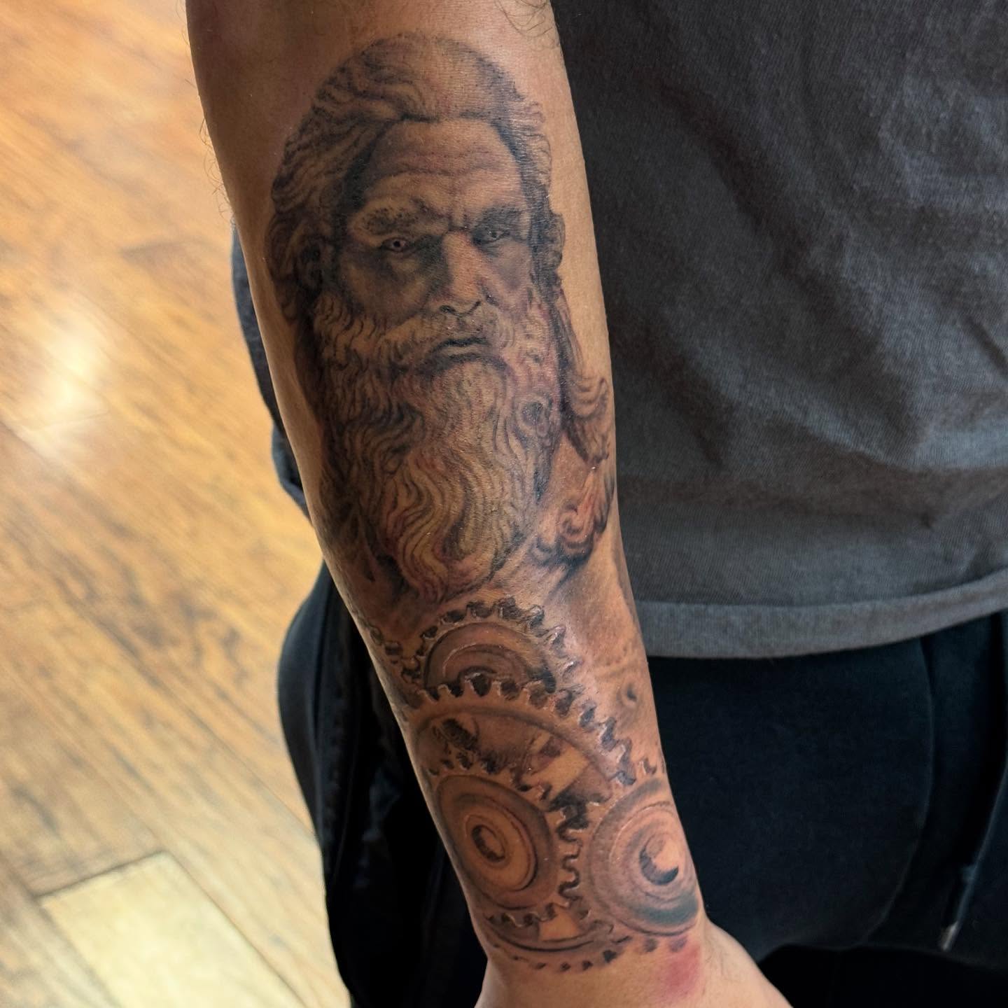 Ancient man with gears realism tattoo on the forearm by Kyle J. Bishop