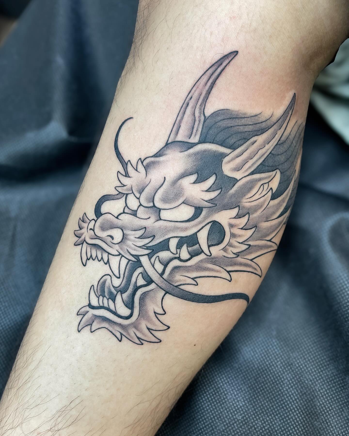 Dragon black and grey tattoo on the forearm by Kelsi Steffensen