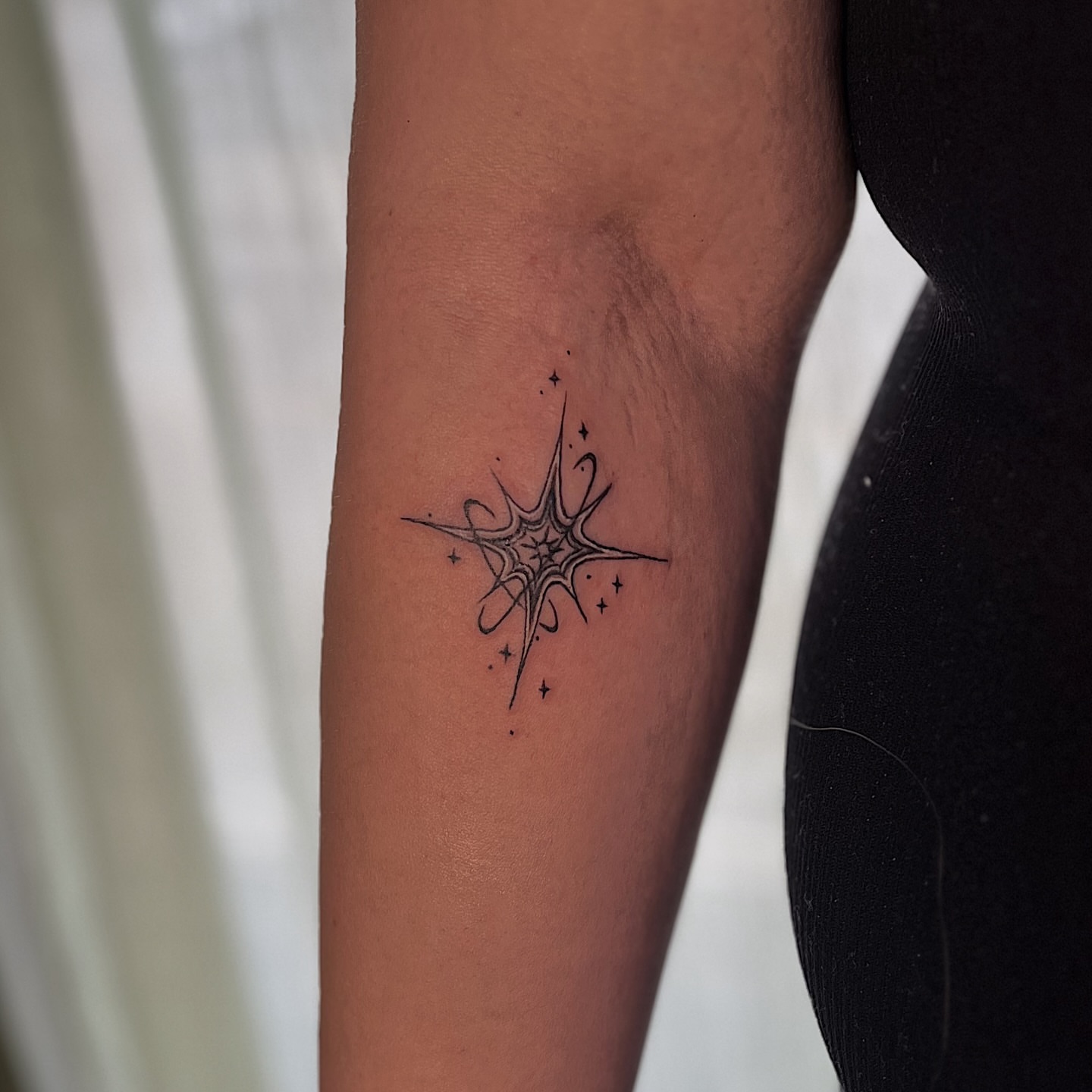Spider web geometric tattoo on the forearm by Nikki Ward