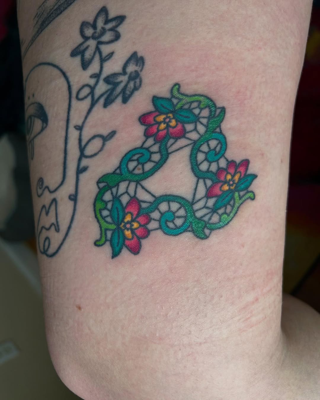 Lace and flowers tattoo on the forearm by Emma D