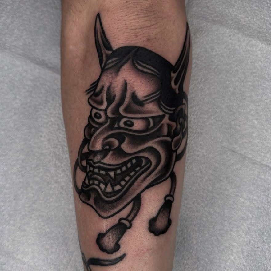 Demon mask black and grey tattoo on the forearm by John Lemon