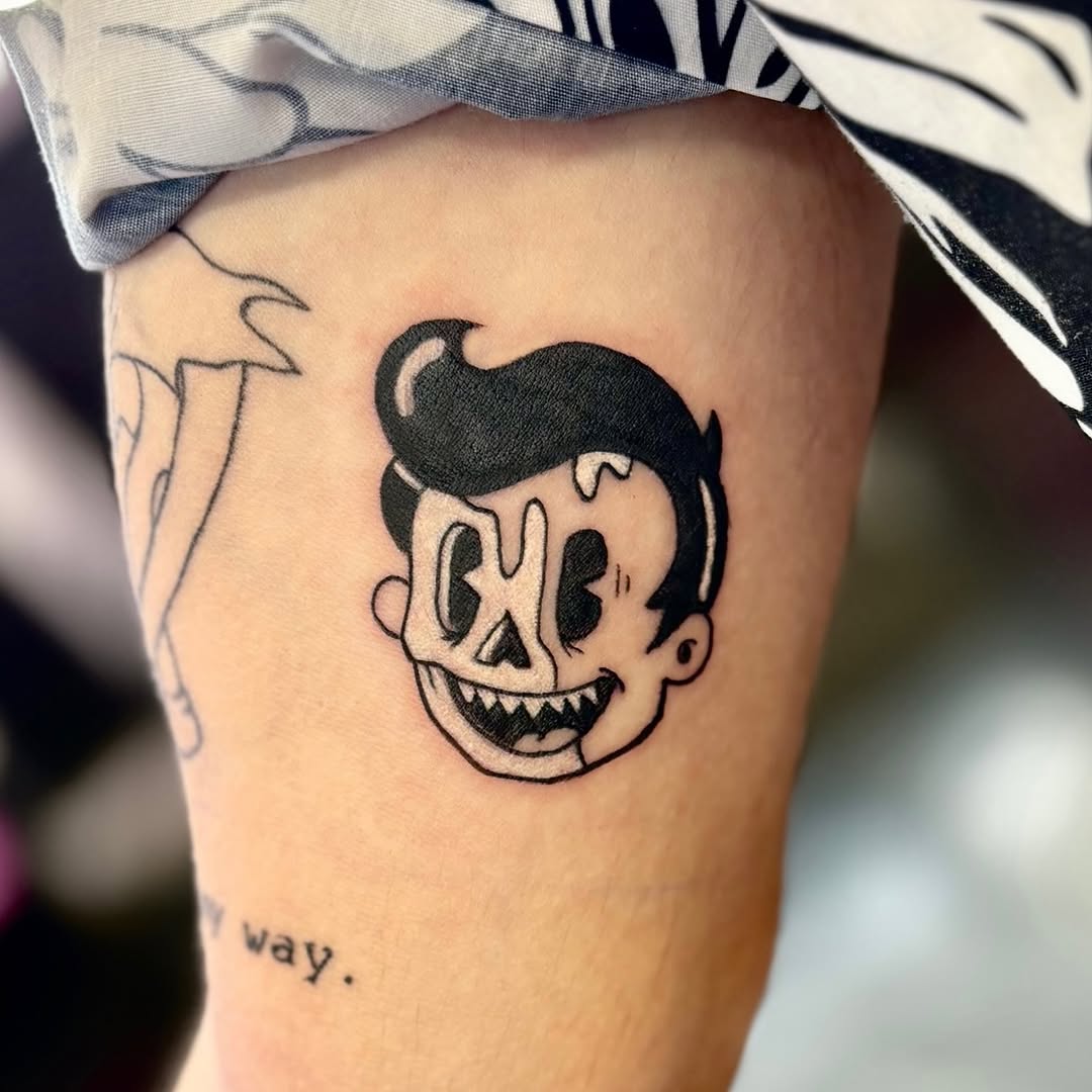 Cartoon character head ignorant tattoo on the forearm by Sally Darling
