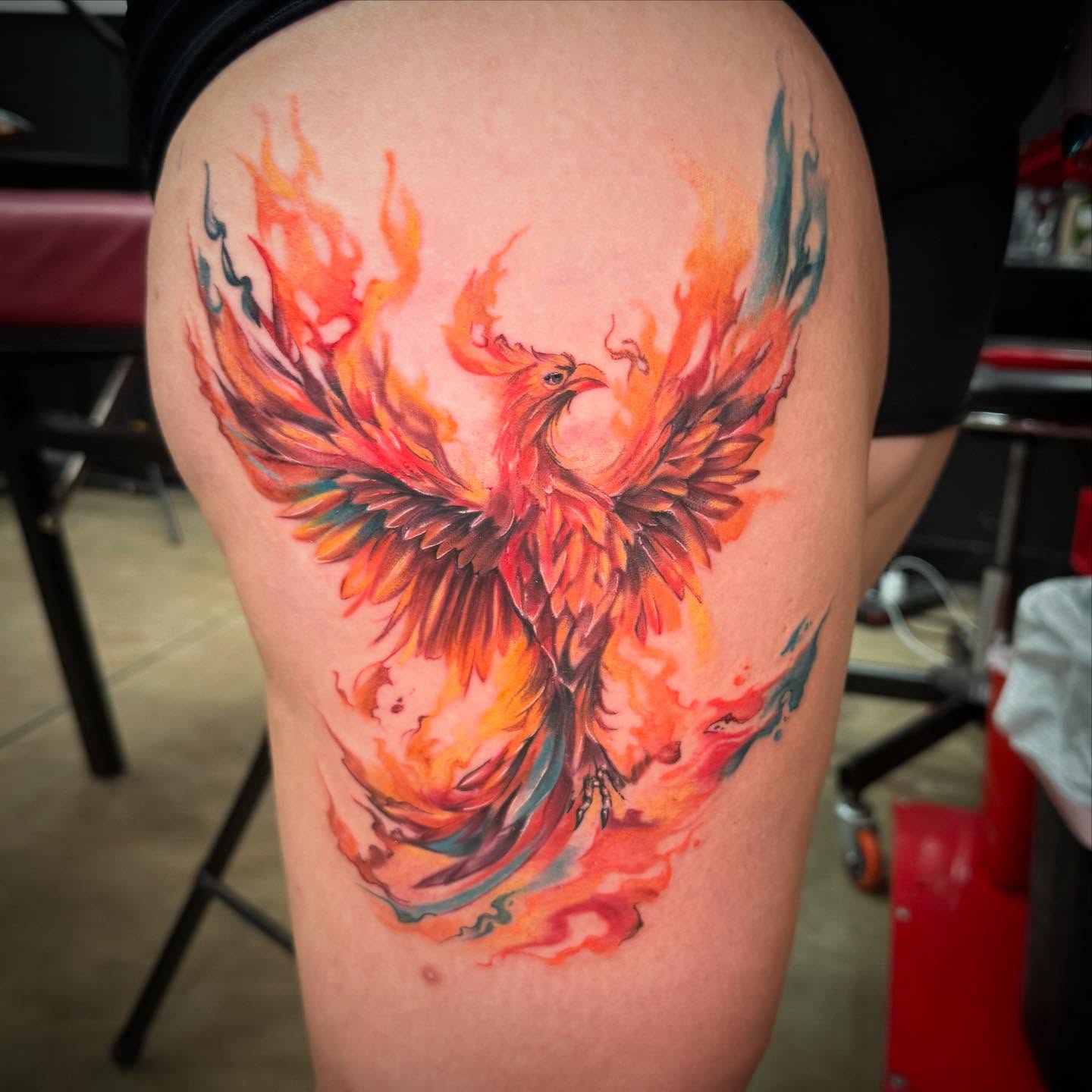 Phoenix watercolor tattoo on the thigh by Shawn Cook