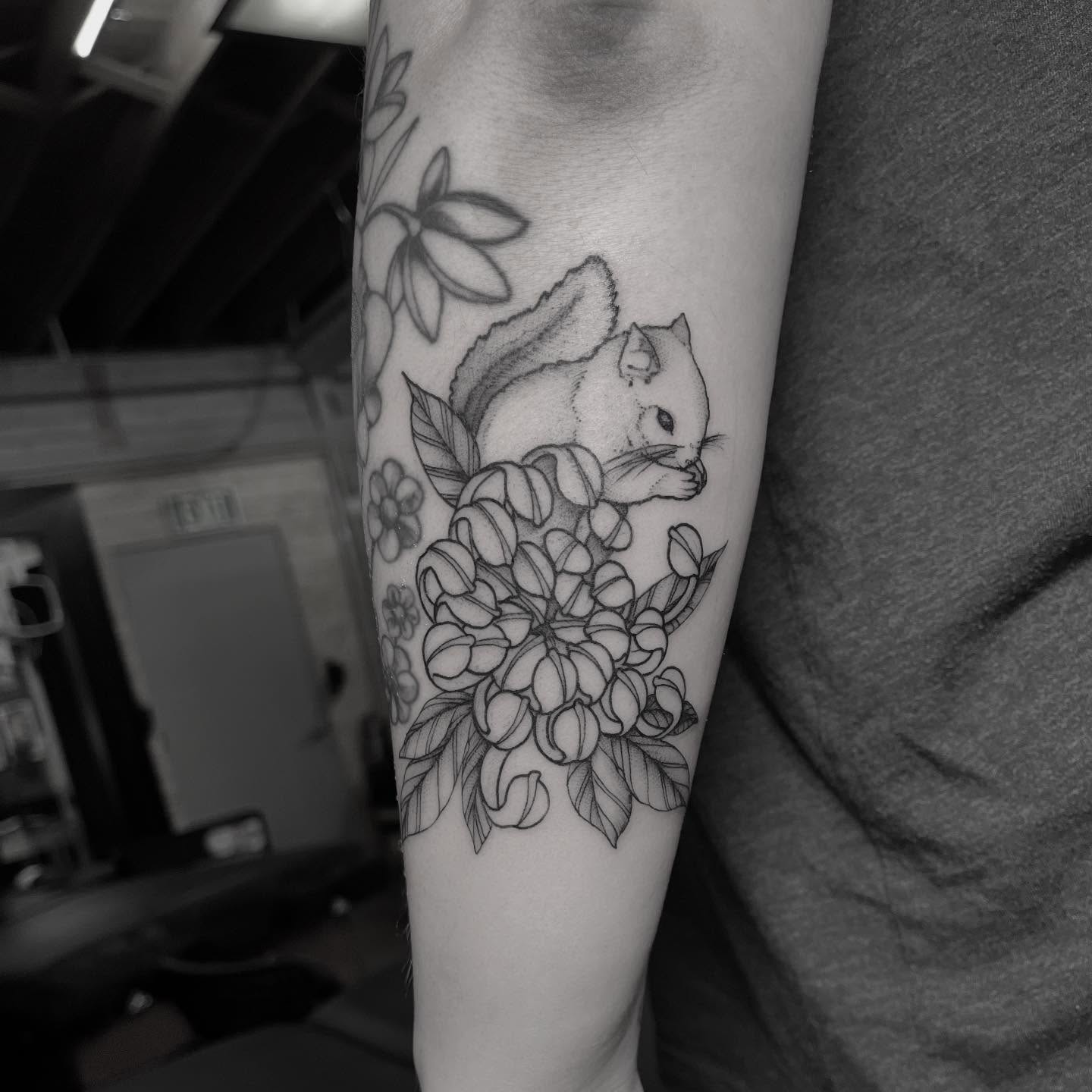 Squirrel and flowers realism tattoo on the forearm by Dallas Davis