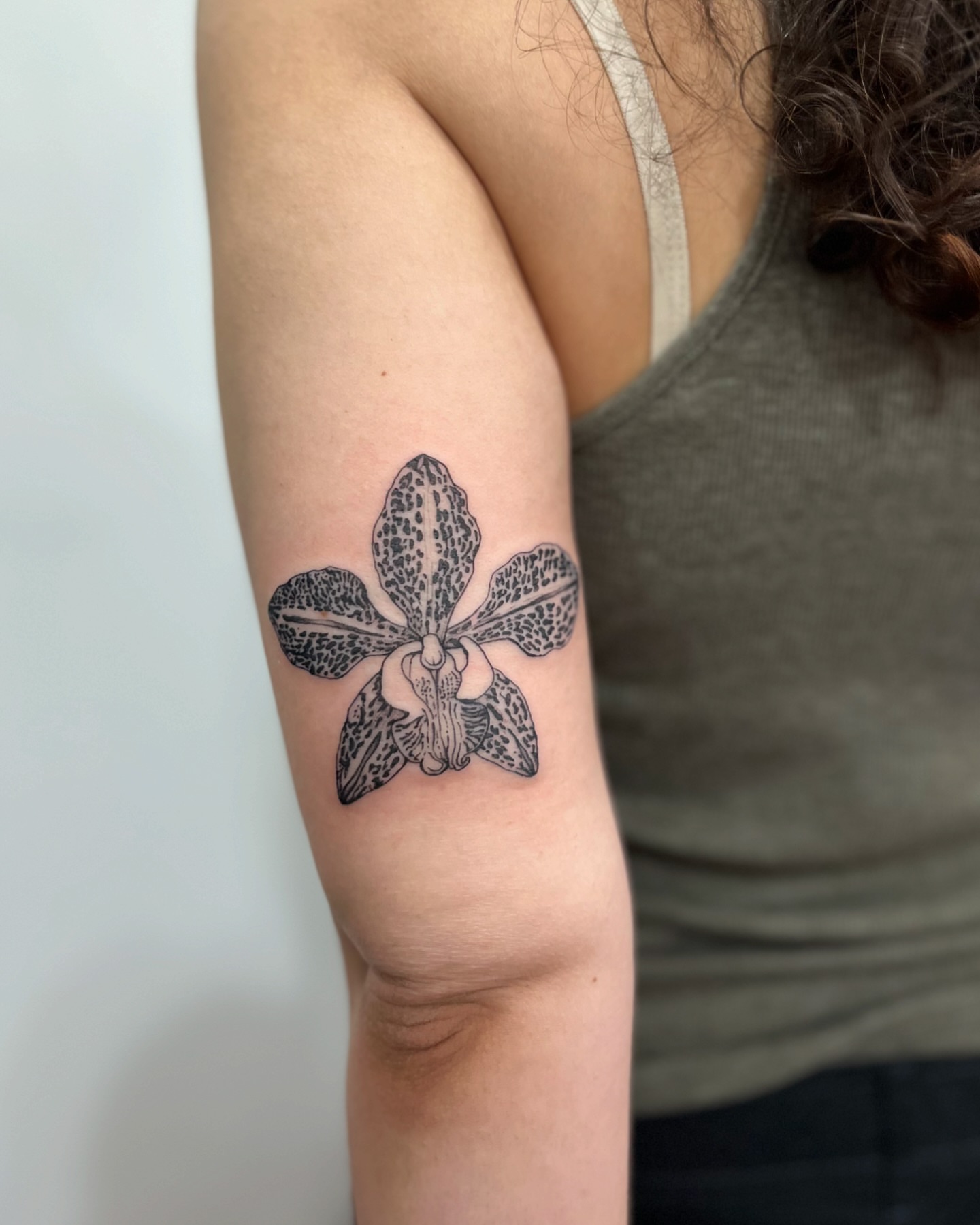 Orchid black and grey tattoo on the forearm by Ying Xeon