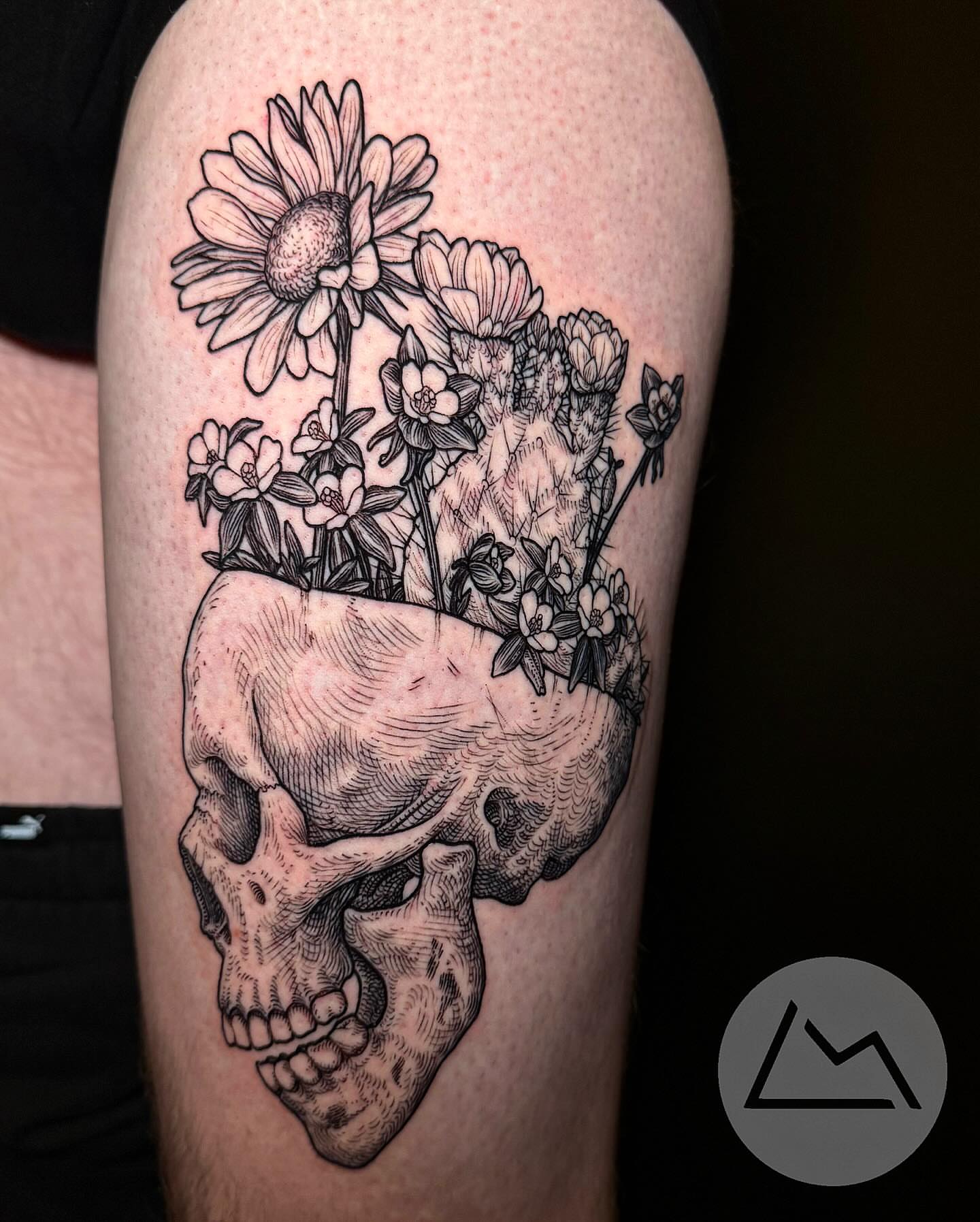 Skull with flowers black and grey tattoo on the thigh by Landon Morgan