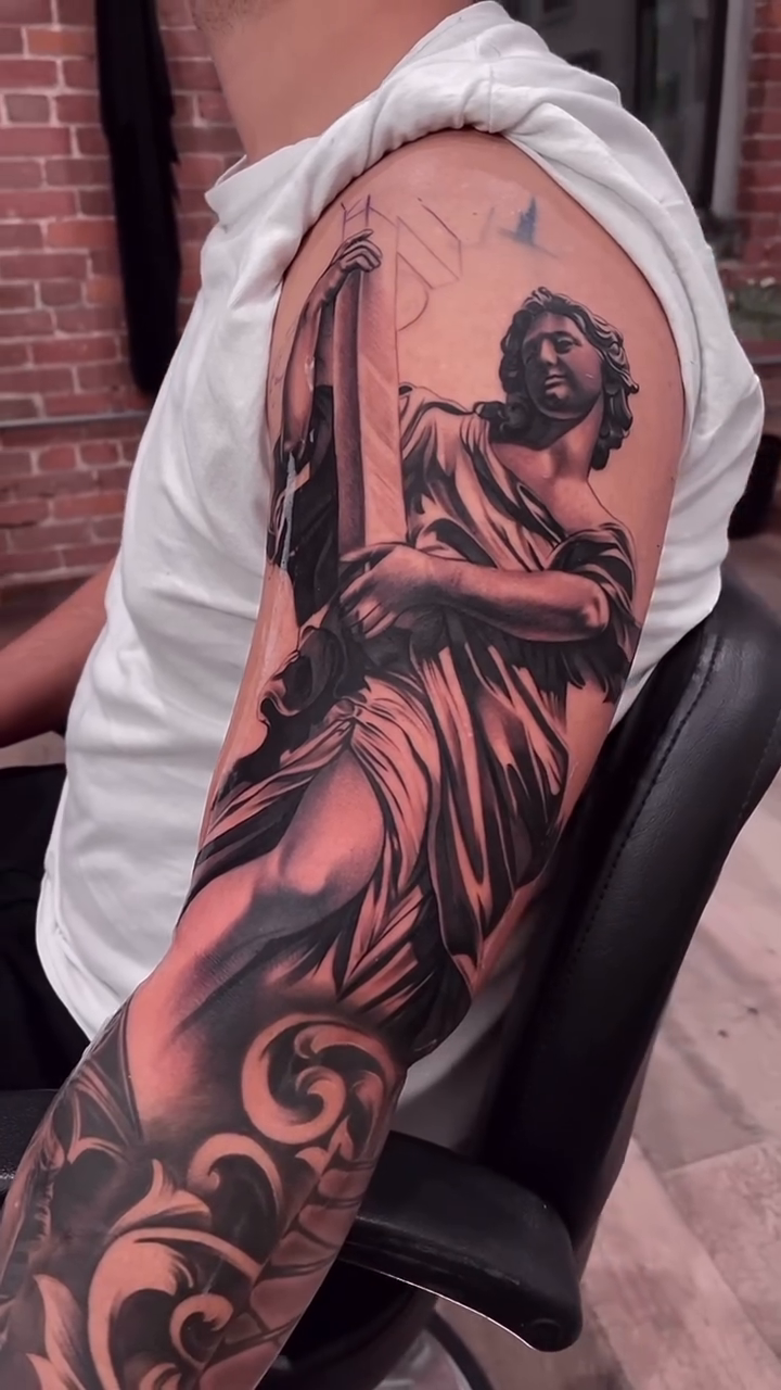 Angel holding a tablet realism tattoo by Erick Gutierrez, Las Vegas, Nevada