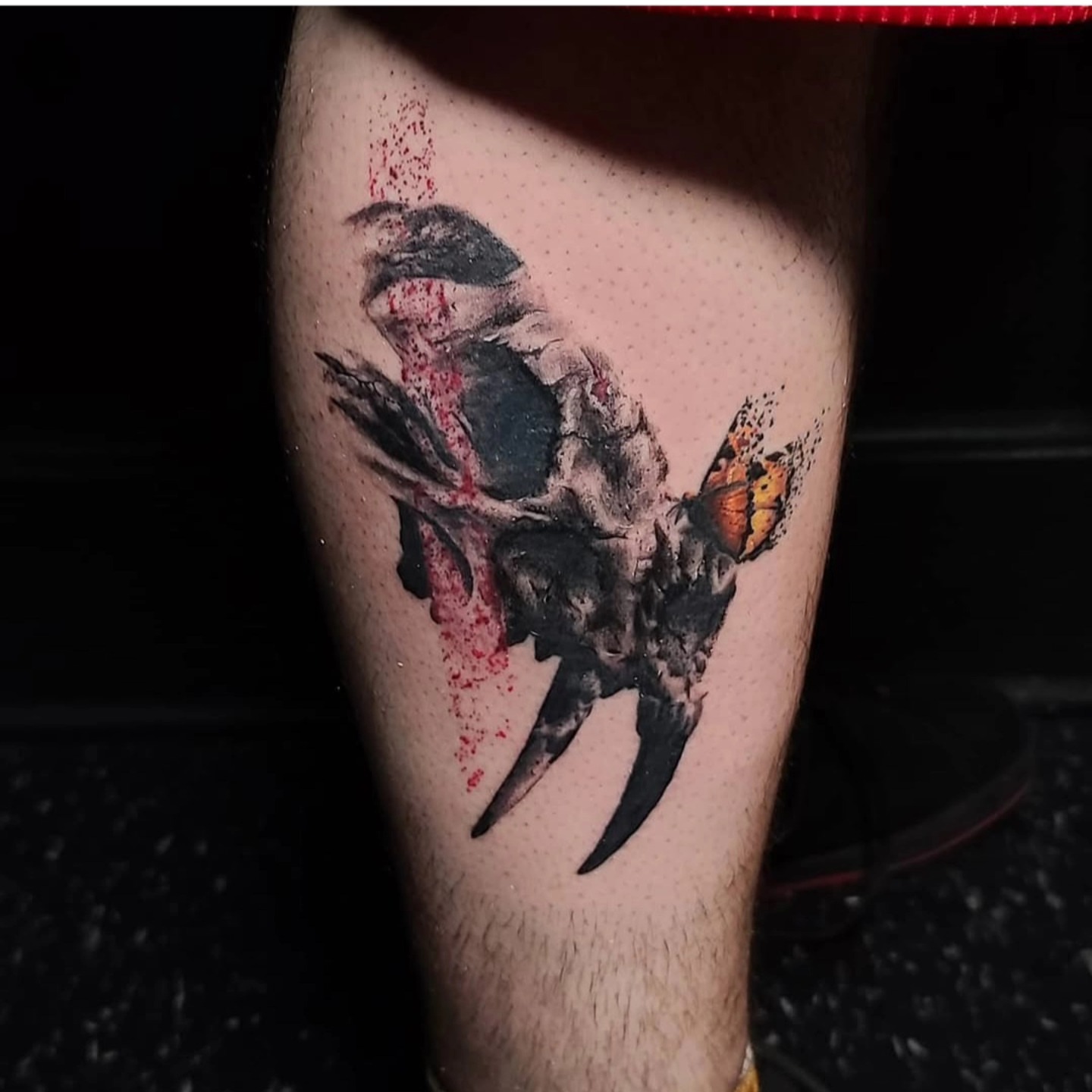 Skull with butterfly dotwork tattoo on the calf by Drew King