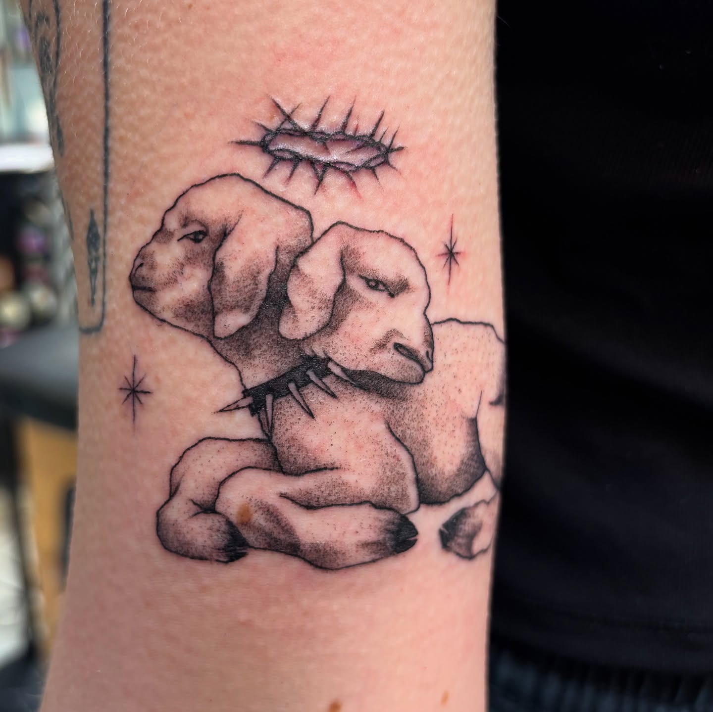 Two dogs with thorns dotwork tattoo on the forearm by Jordan Wray