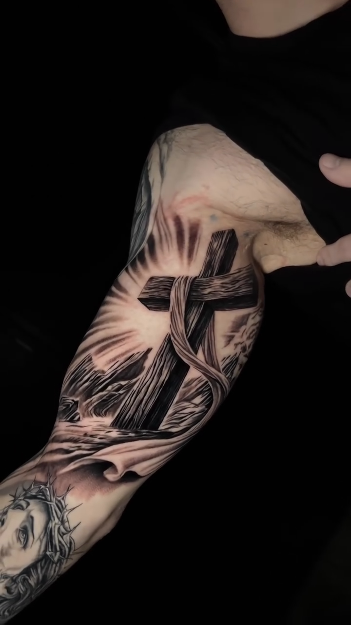 Cross with religious imagery realism tattoo by Tommy Nguyen, Eastpointe, Michigan