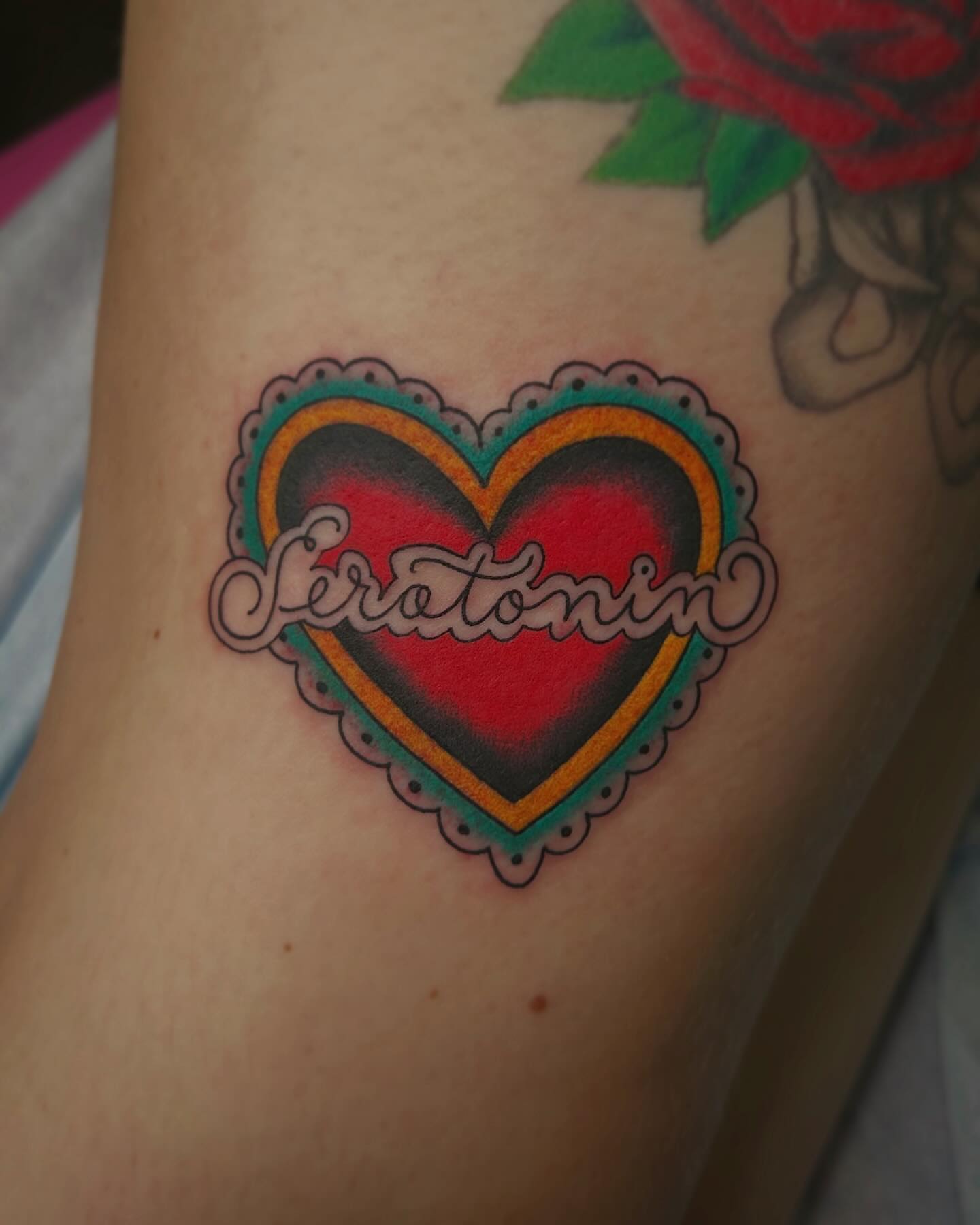 Heart with 'serotonin' American traditional tattoo on the forearm by Kayla Shoffner