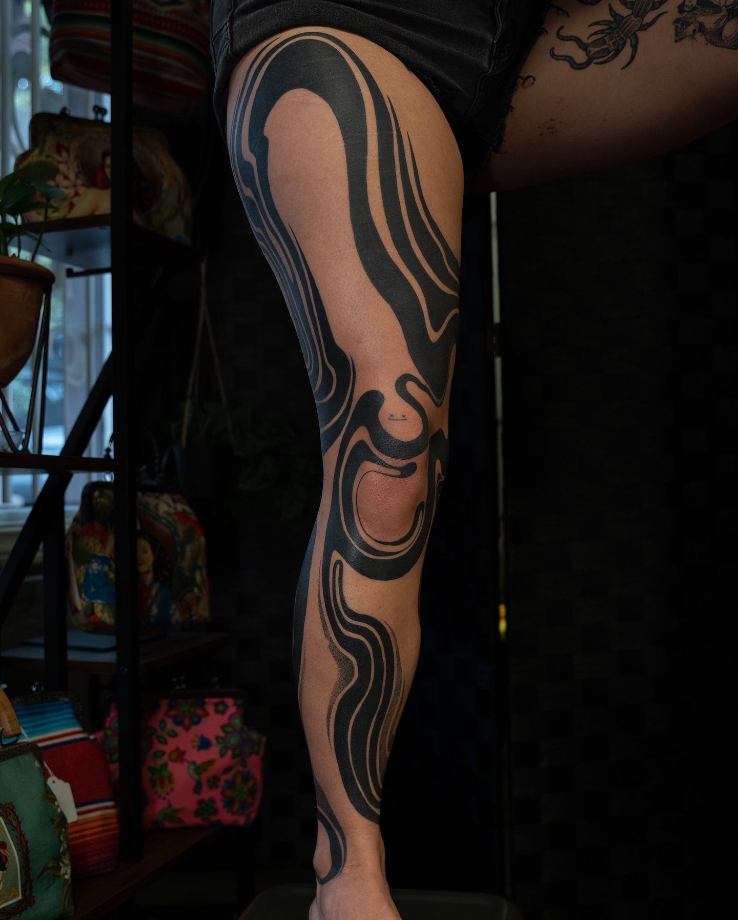 Abstract swirls black and grey tattoo on the leg by Chris Estrada