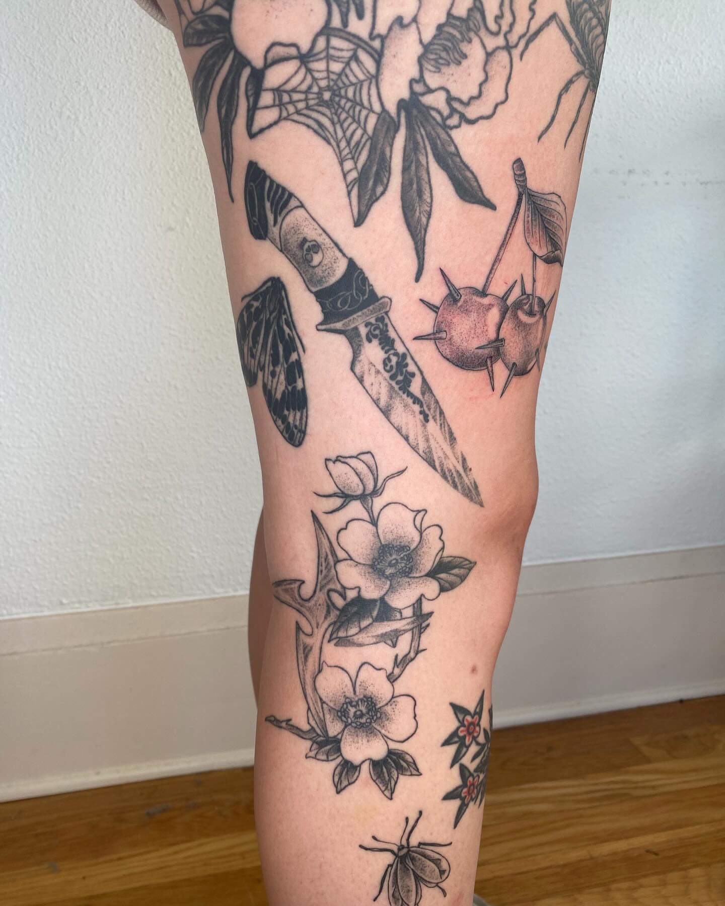 Knife and flowers black and grey tattoo on the forearm by Finley Jordan