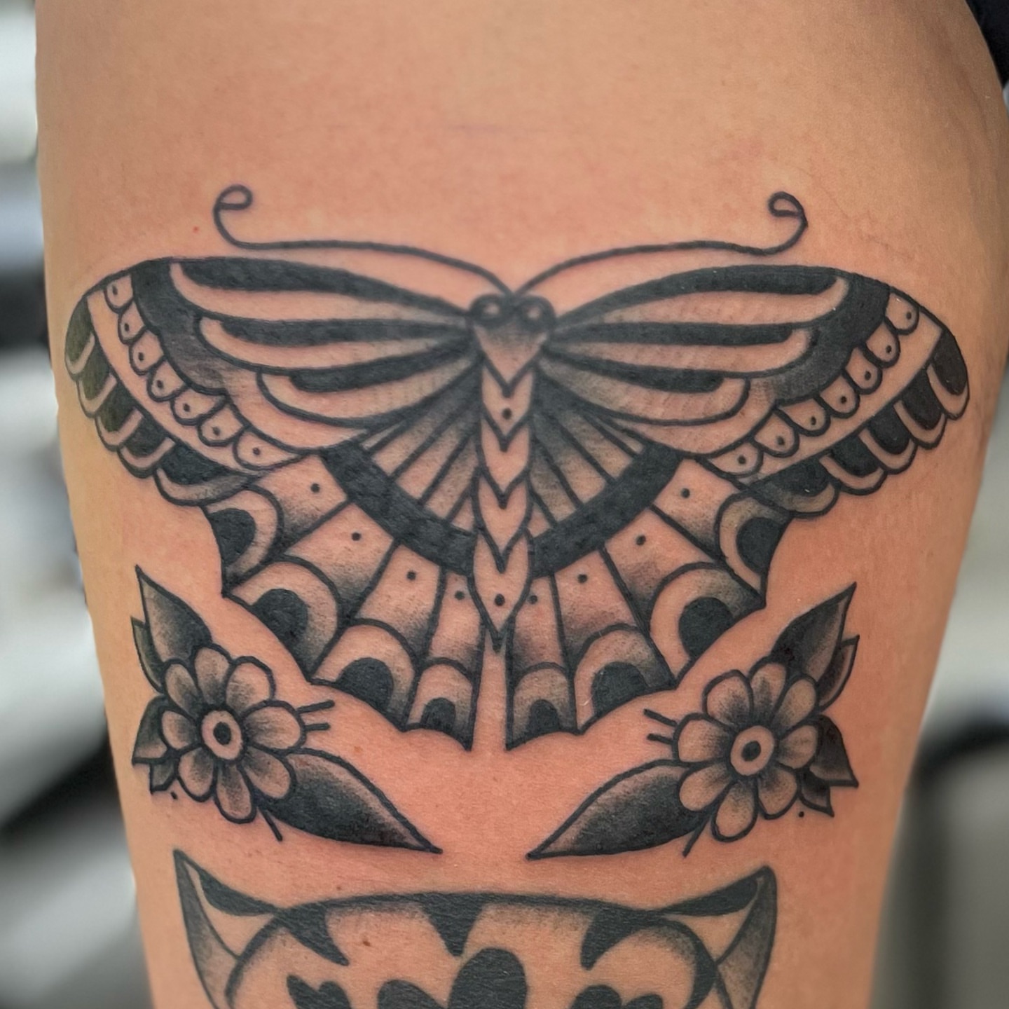 Butterfly American traditional tattoo on the thigh by Ashley Camp