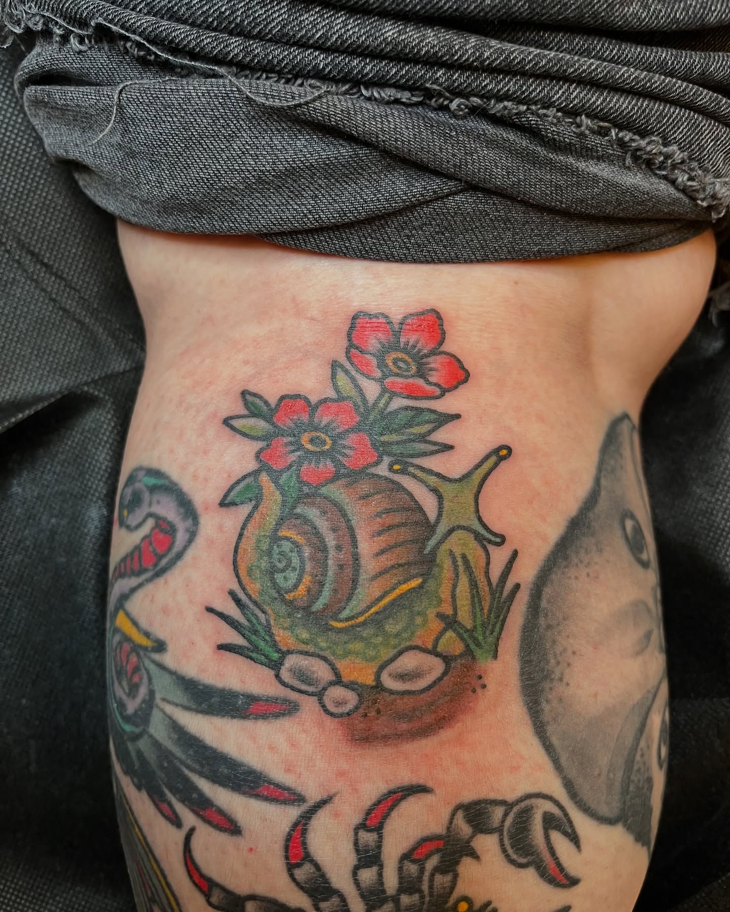 Snail and flowers American traditional tattoo on the thigh by Savannah Brayton, Bethlehem, Pennsylvania