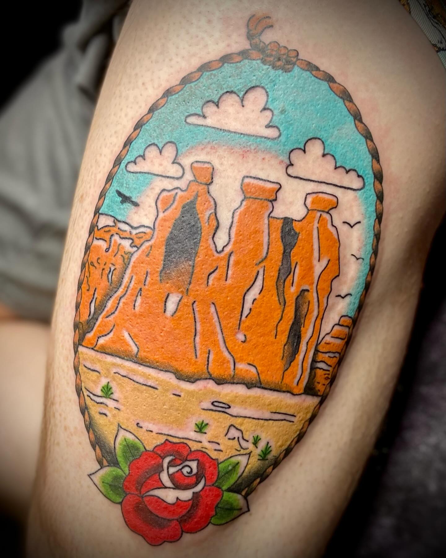 Landscape with rock formations American traditional tattoo on the thigh by Shelbie, Salt Lake City, Utah