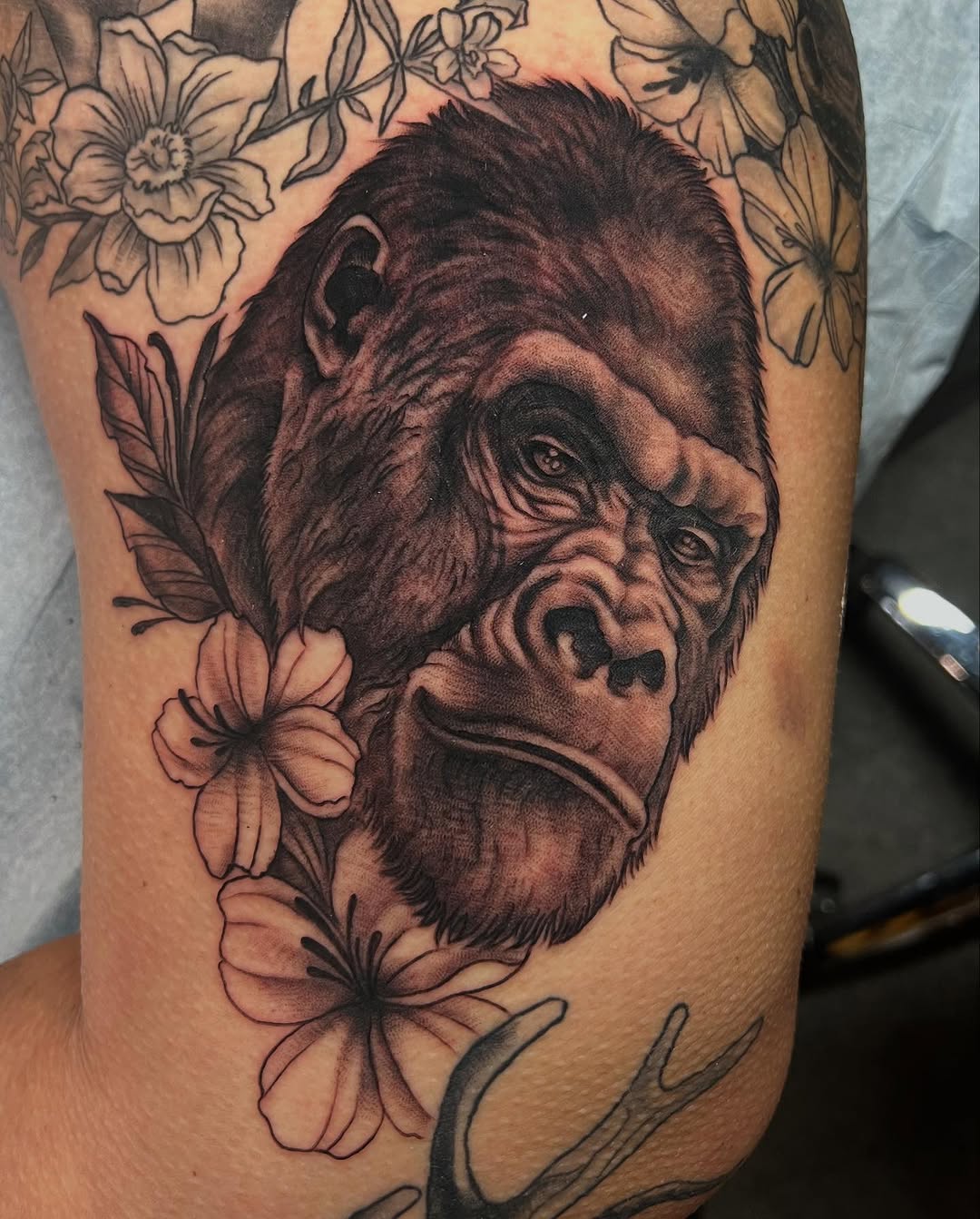 Gorilla head with flowers realism tattoo on the forearm by Dustin Hysell