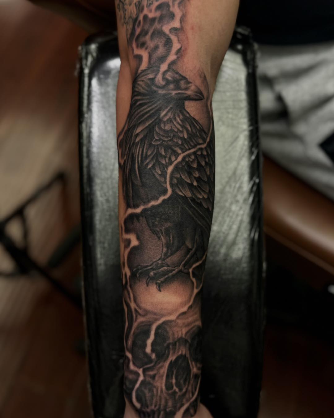 Raven and lightning realism tattoo on the forearm by James Reed Tattoo artist